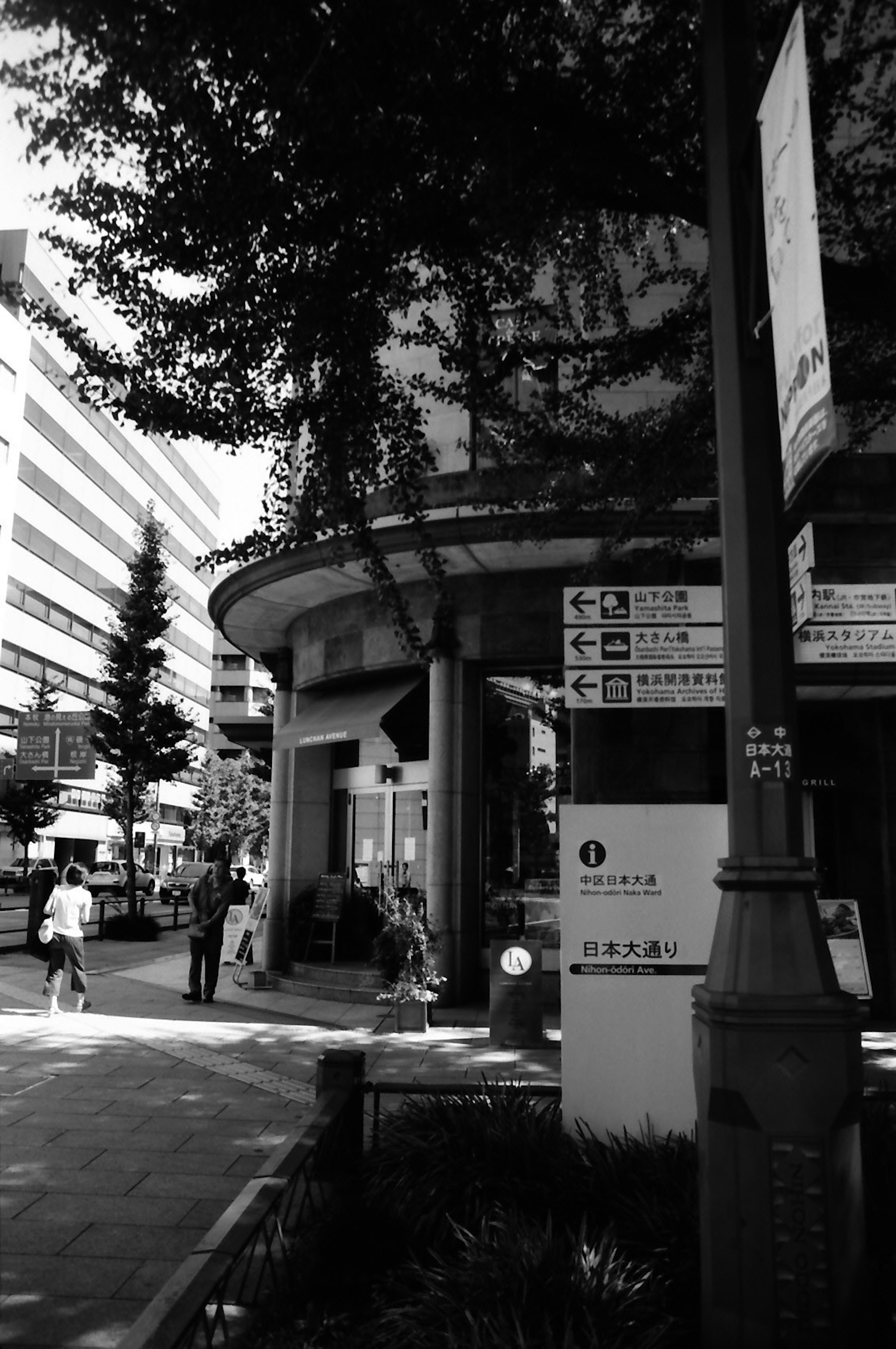 Escena urbana en blanco y negro con un edificio redondo y peatones