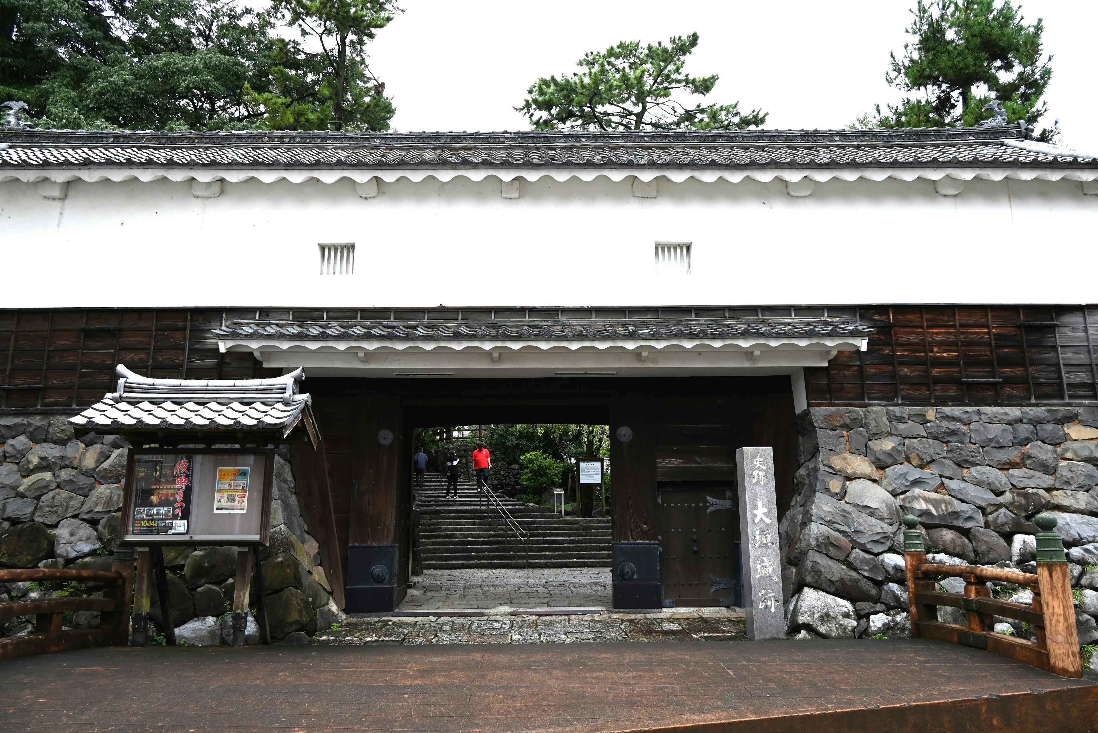 Traditional Japanese gate with stone wall and wooden details