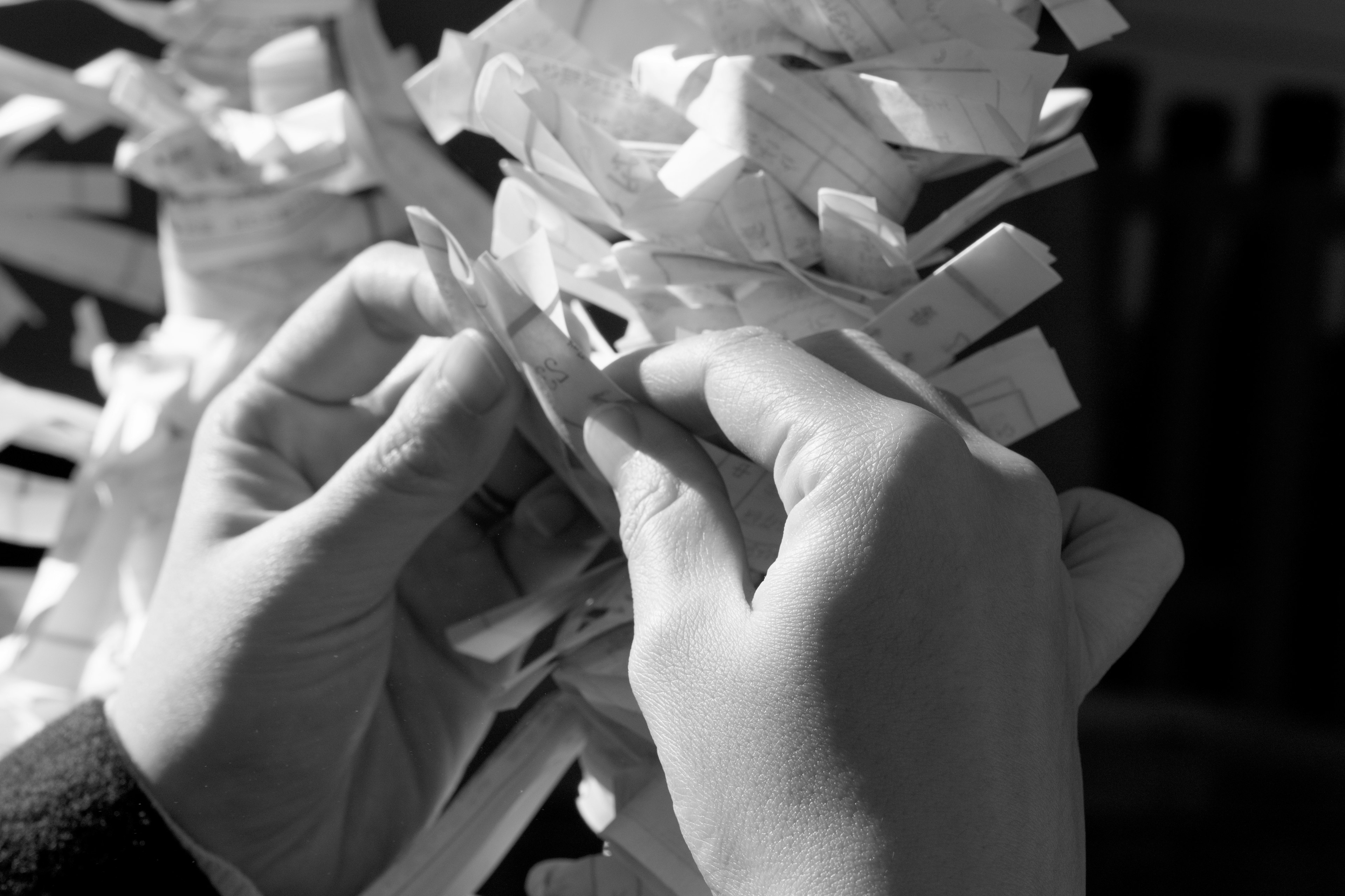 Mains tissant de fines bandes de papier