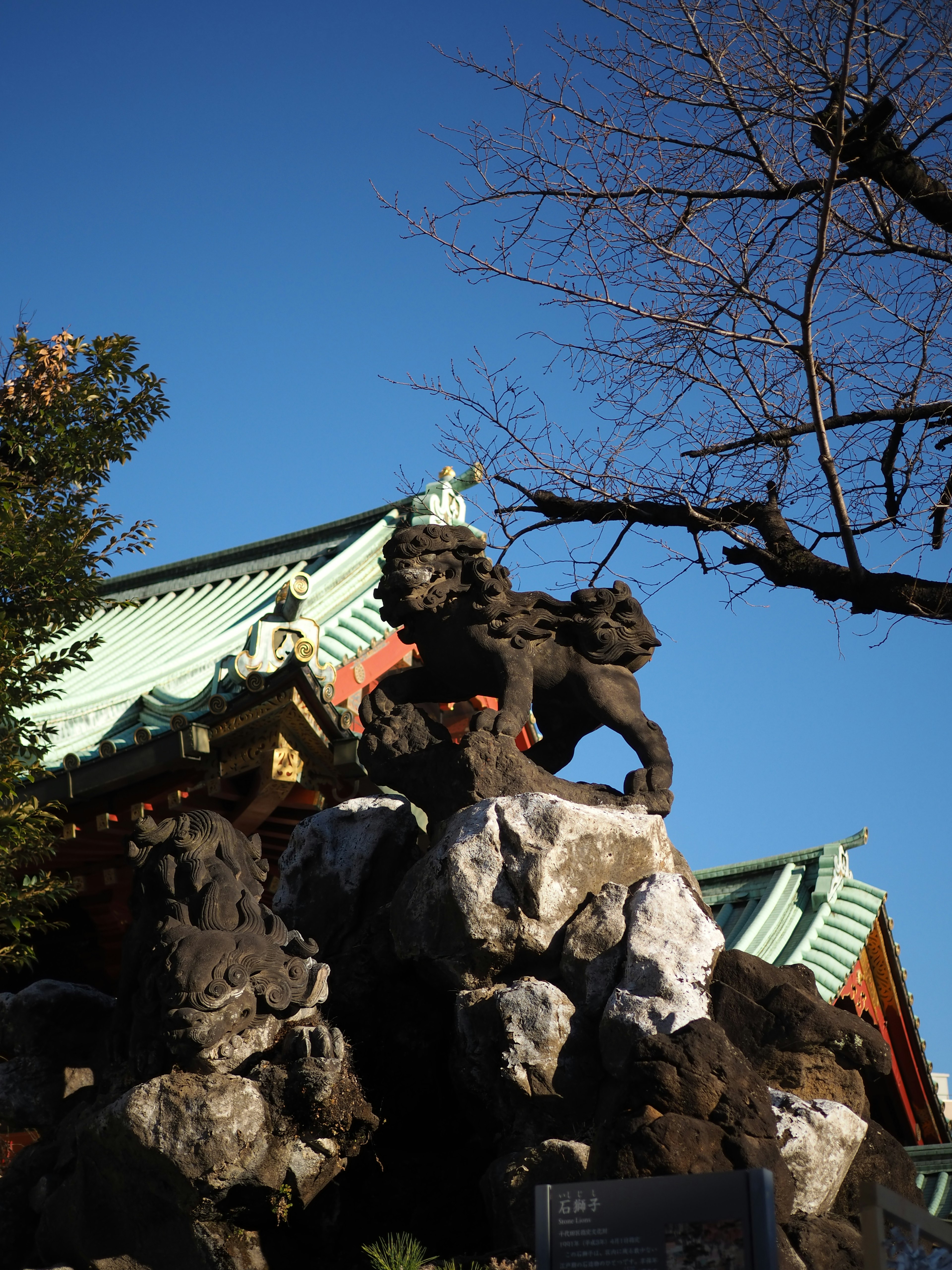 Statue de lion se tenant sur des rochers avec un ciel bleu clair