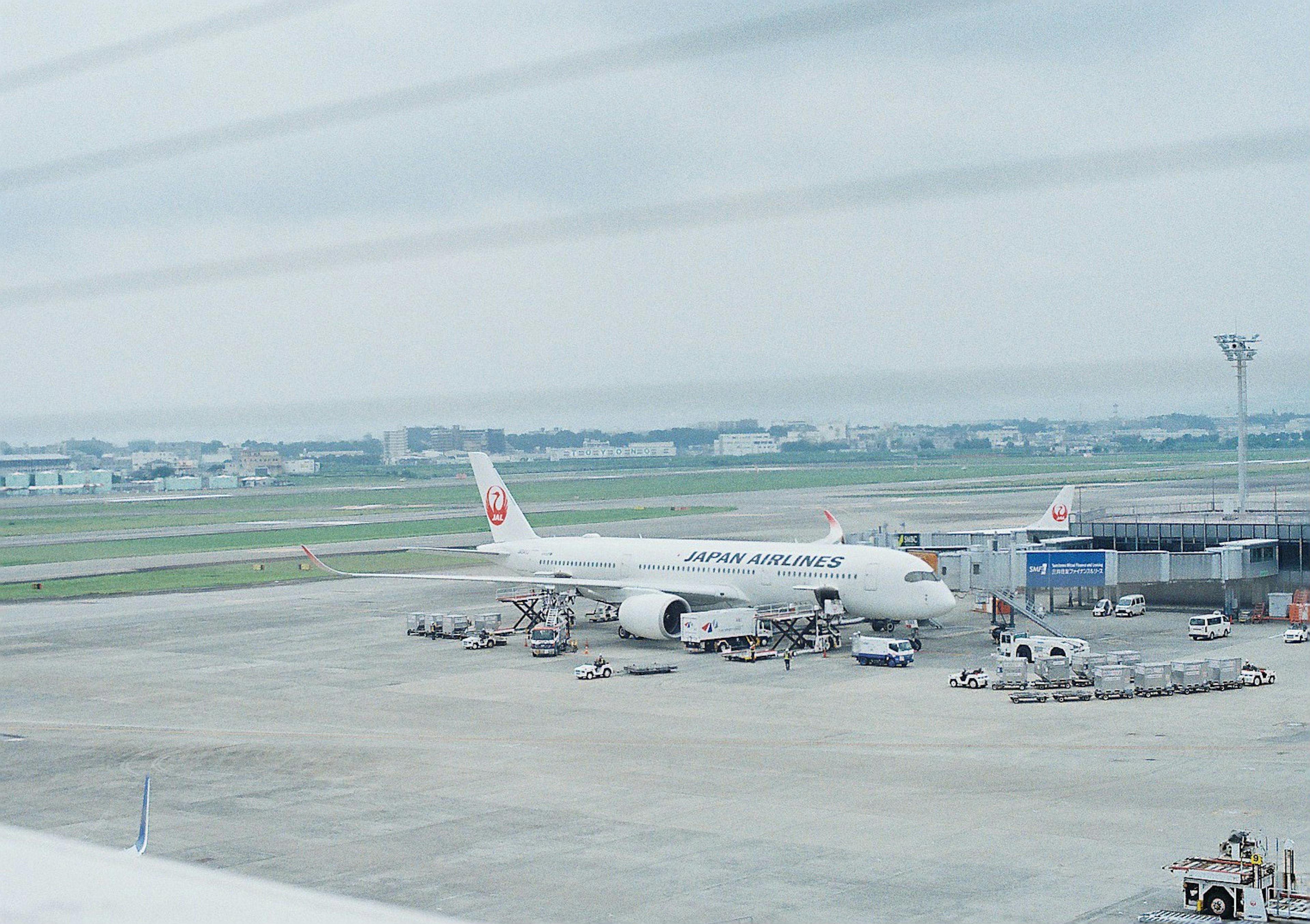 공항 활주로에 주차된 비행기와 터미널이 보이는 장면