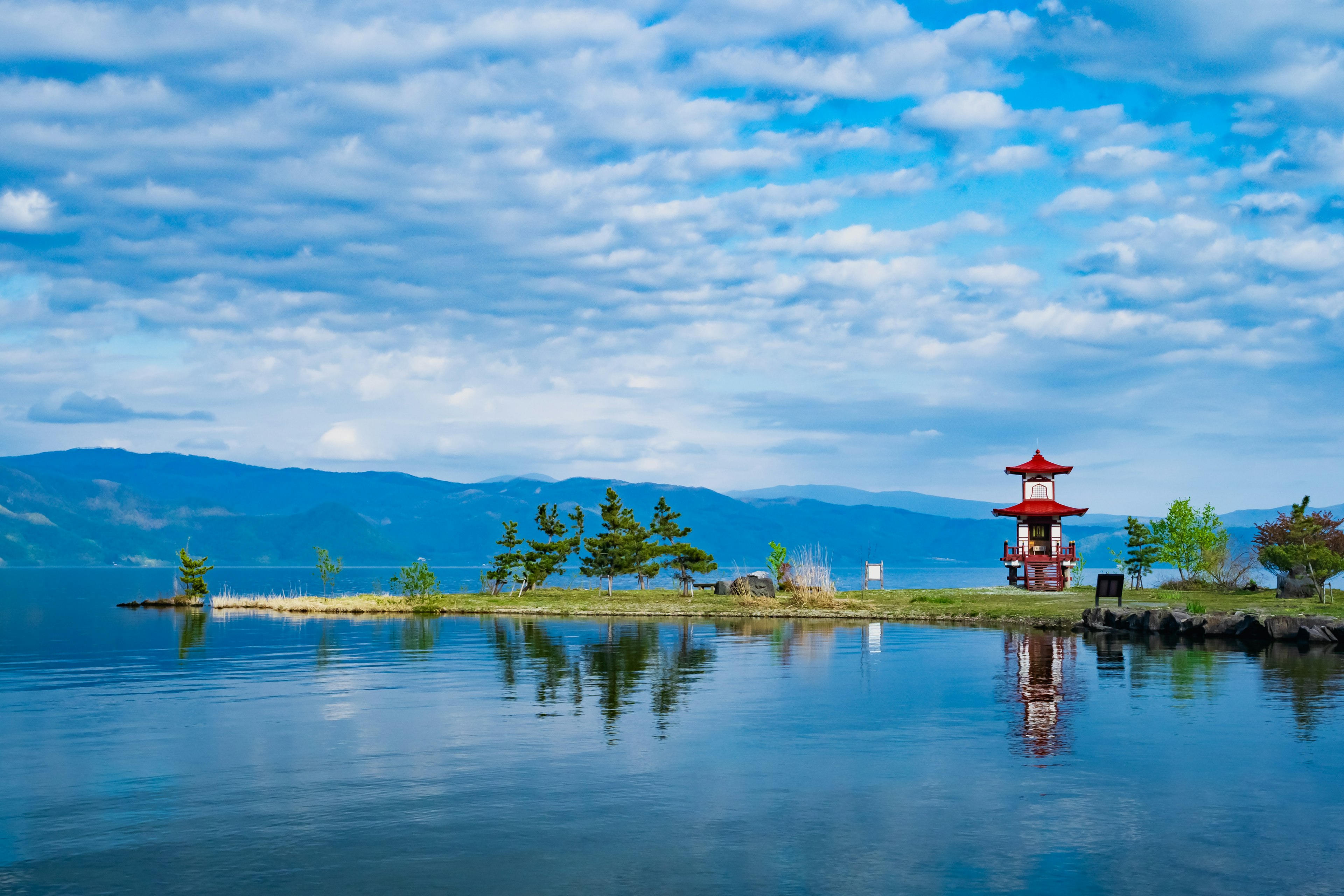 Malersicher Blick auf den See mit einem roten Pavillon und Spiegelungen auf dem Wasser