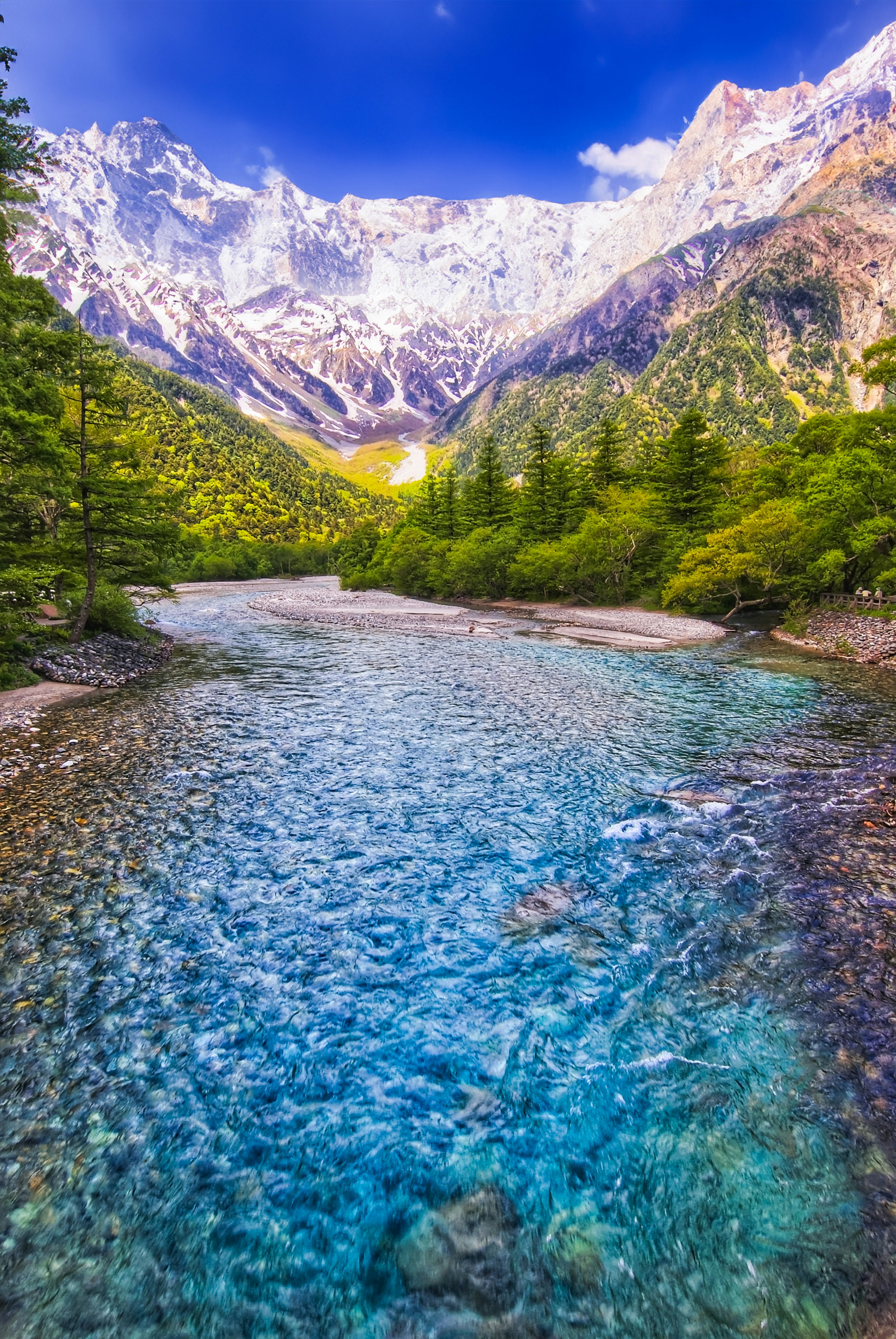 Vista escénica de un río claro rodeado de majestuosas montañas