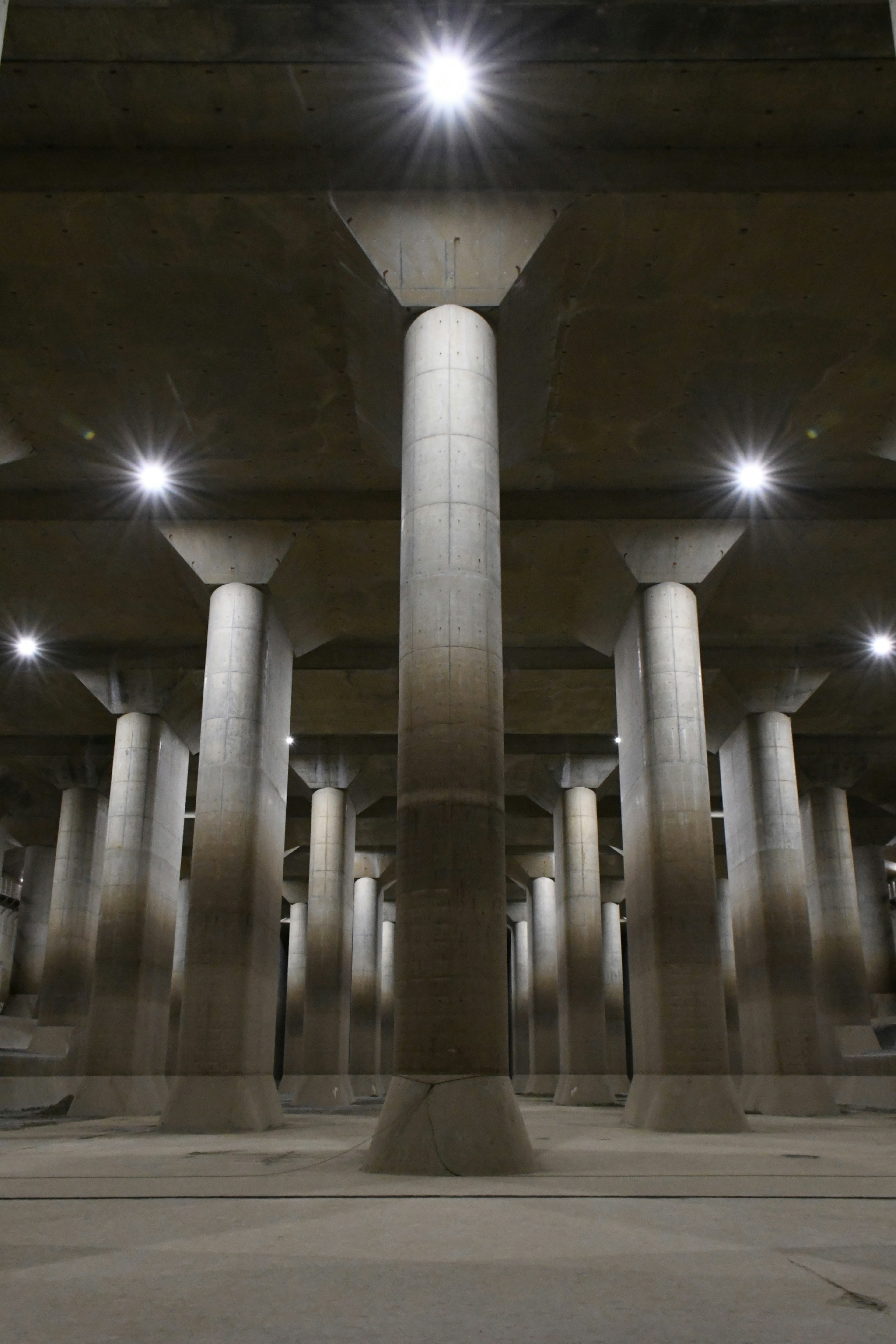 Espace souterrain avec des piliers en béton et un éclairage lumineux