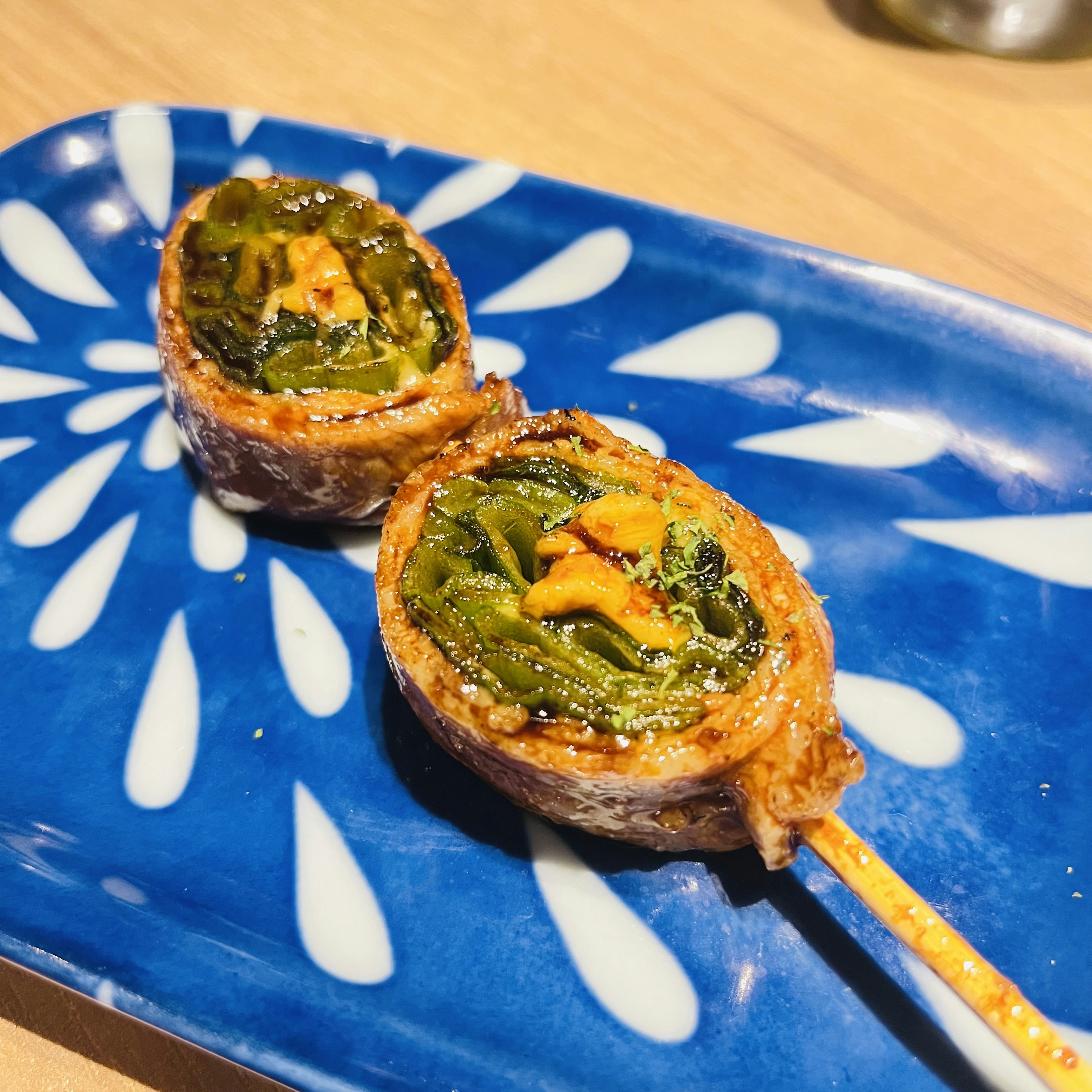 Brocheta de verduras y carne a la parrilla presentada en un plato azul