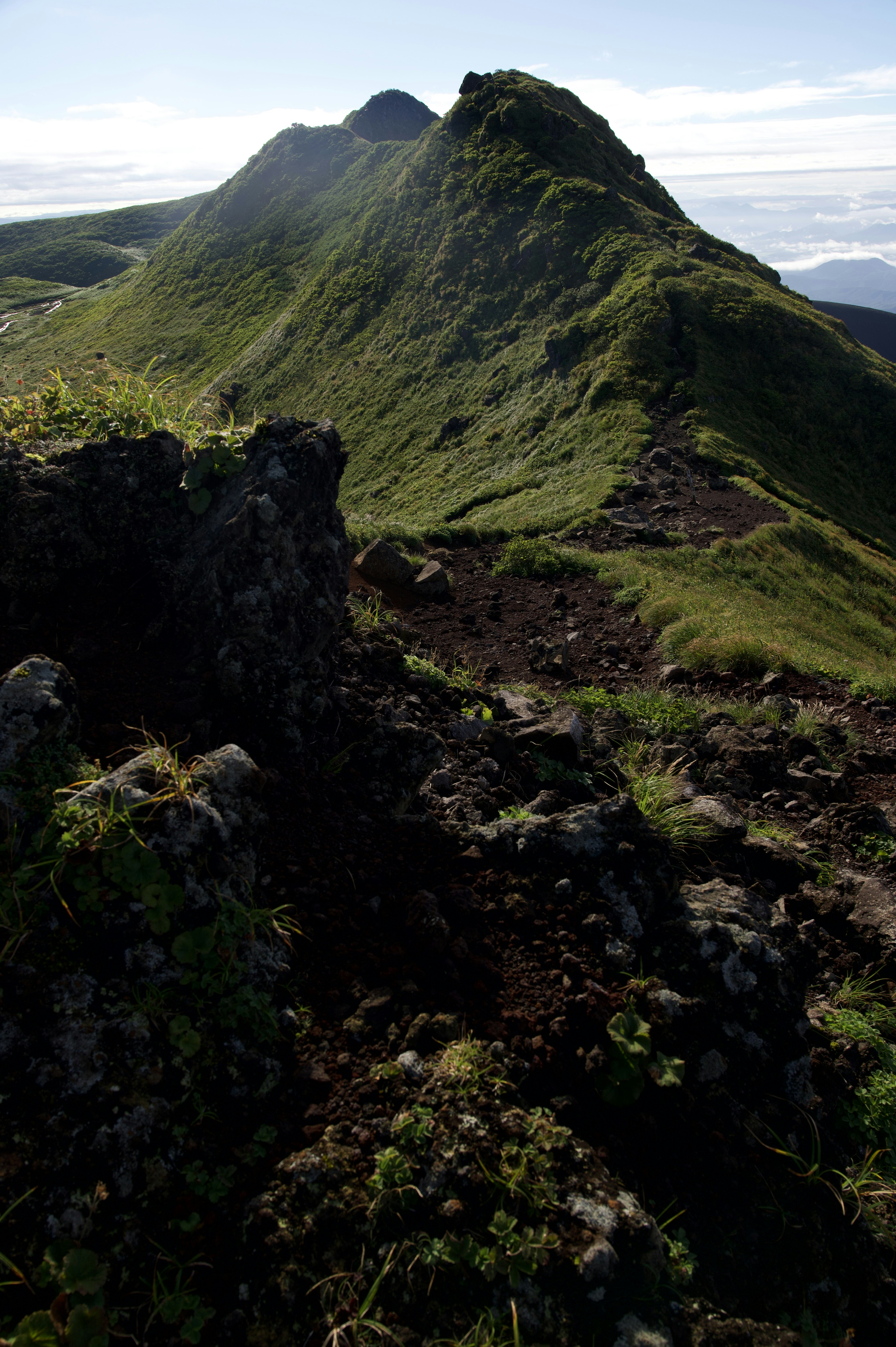 Üppige grüne Berglandschaft mit klarem blauen Himmel