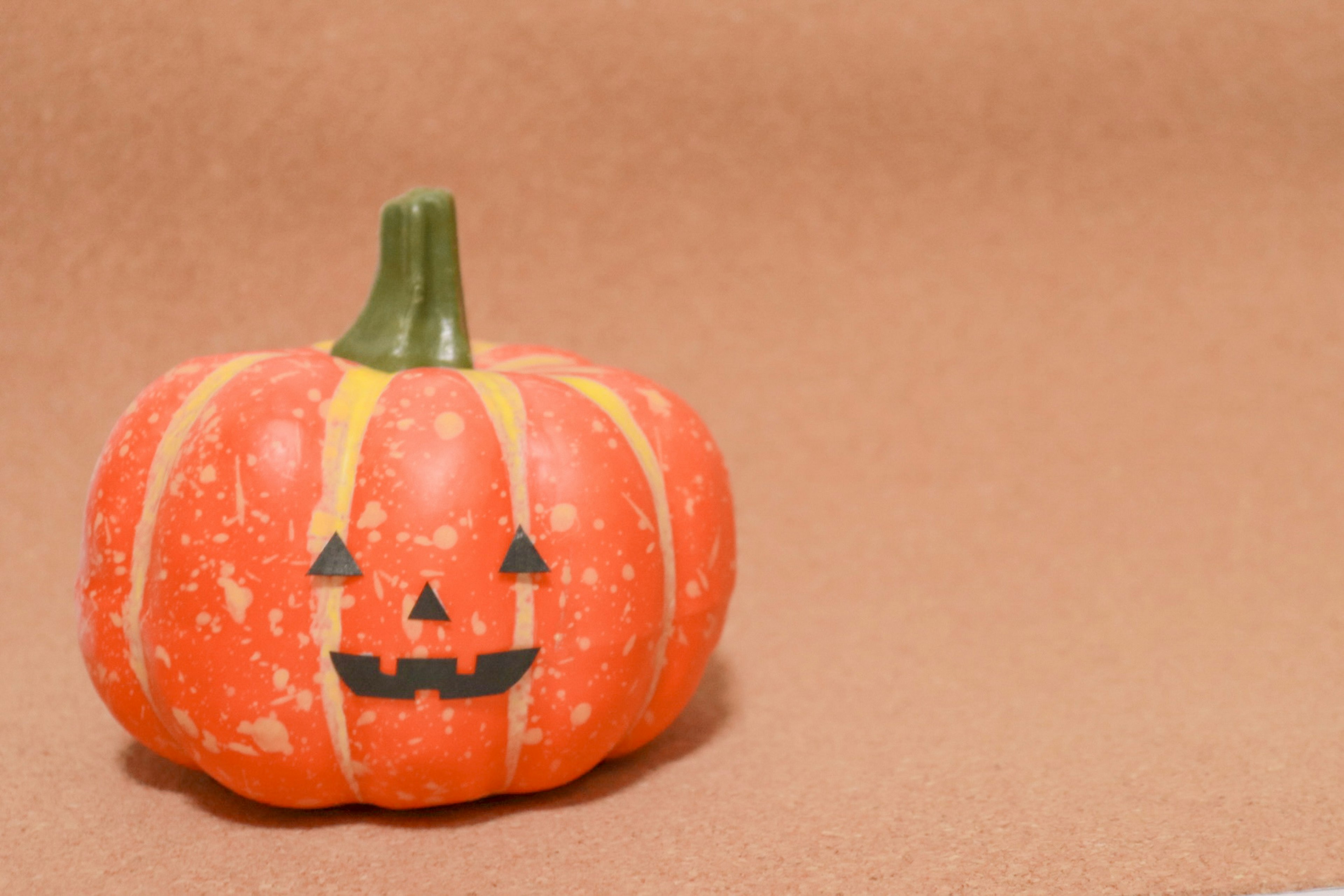 Zucca di Halloween con un design di faccia nera su pelle arancione