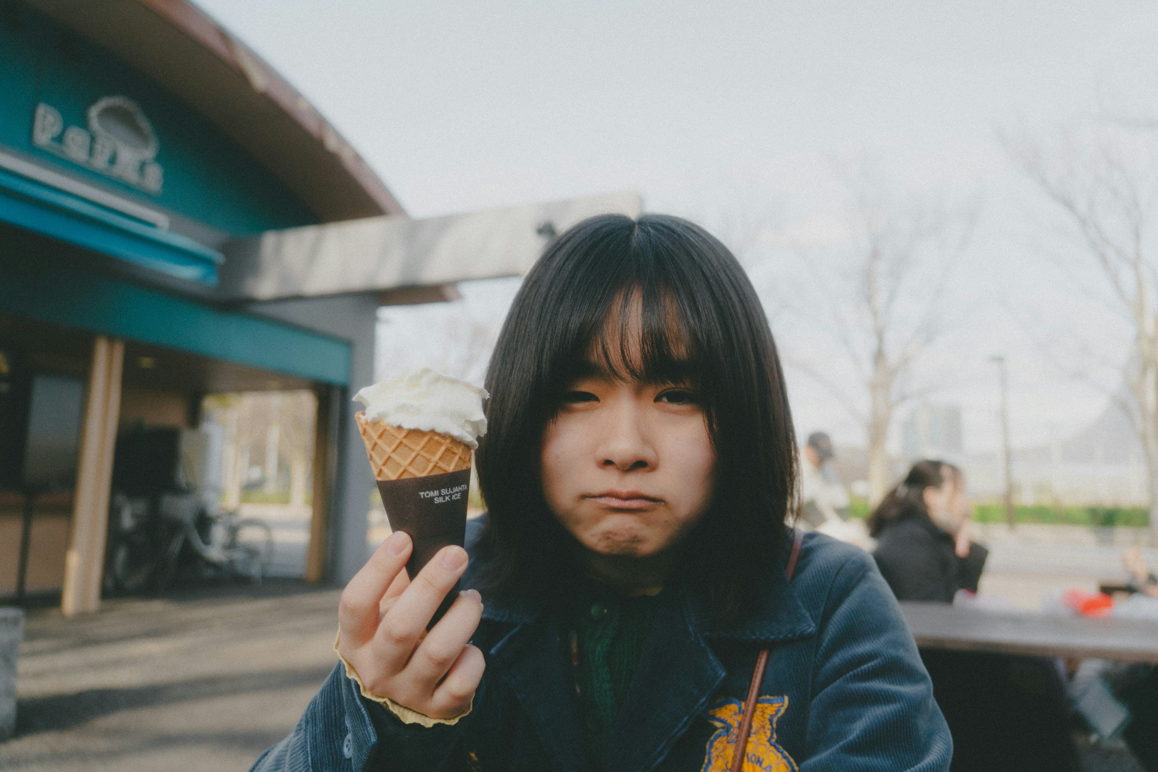 アイスクリームを持った少女が不満そうな表情をしている