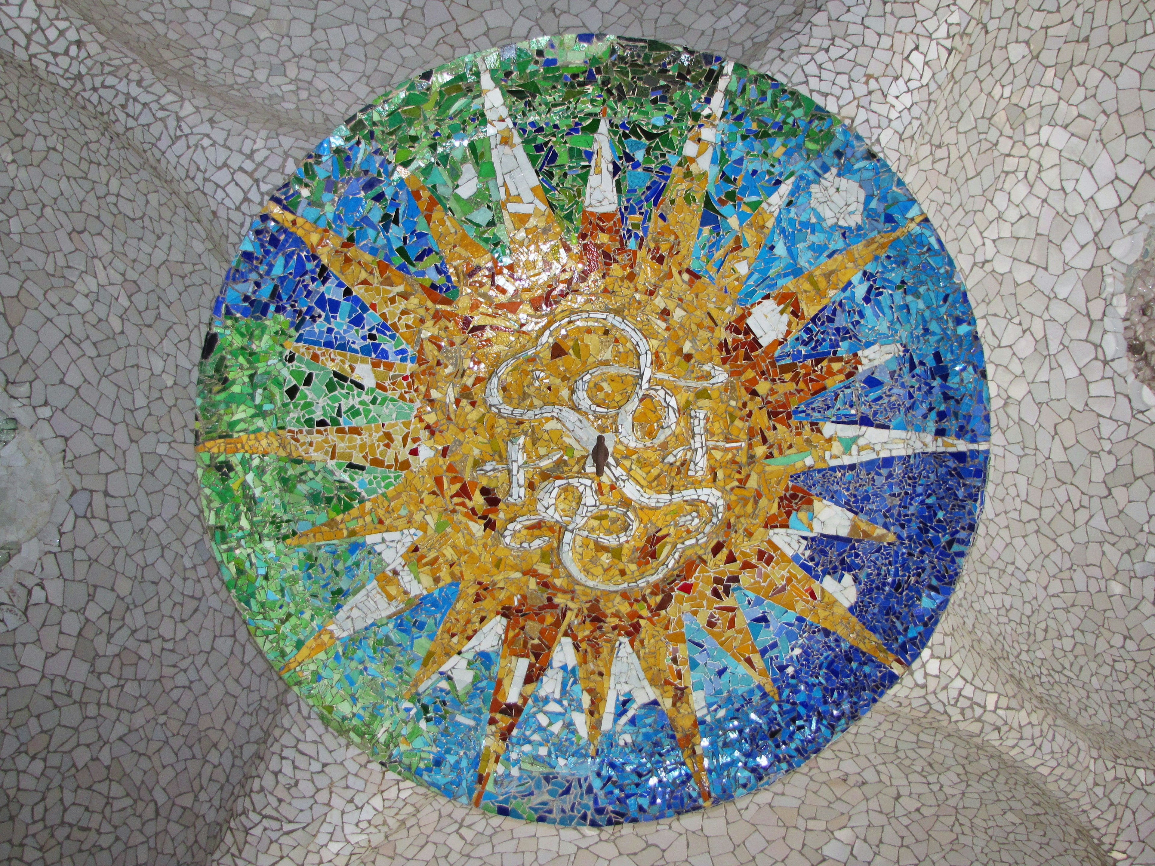 Colorful mosaic sun pattern on a circular tile