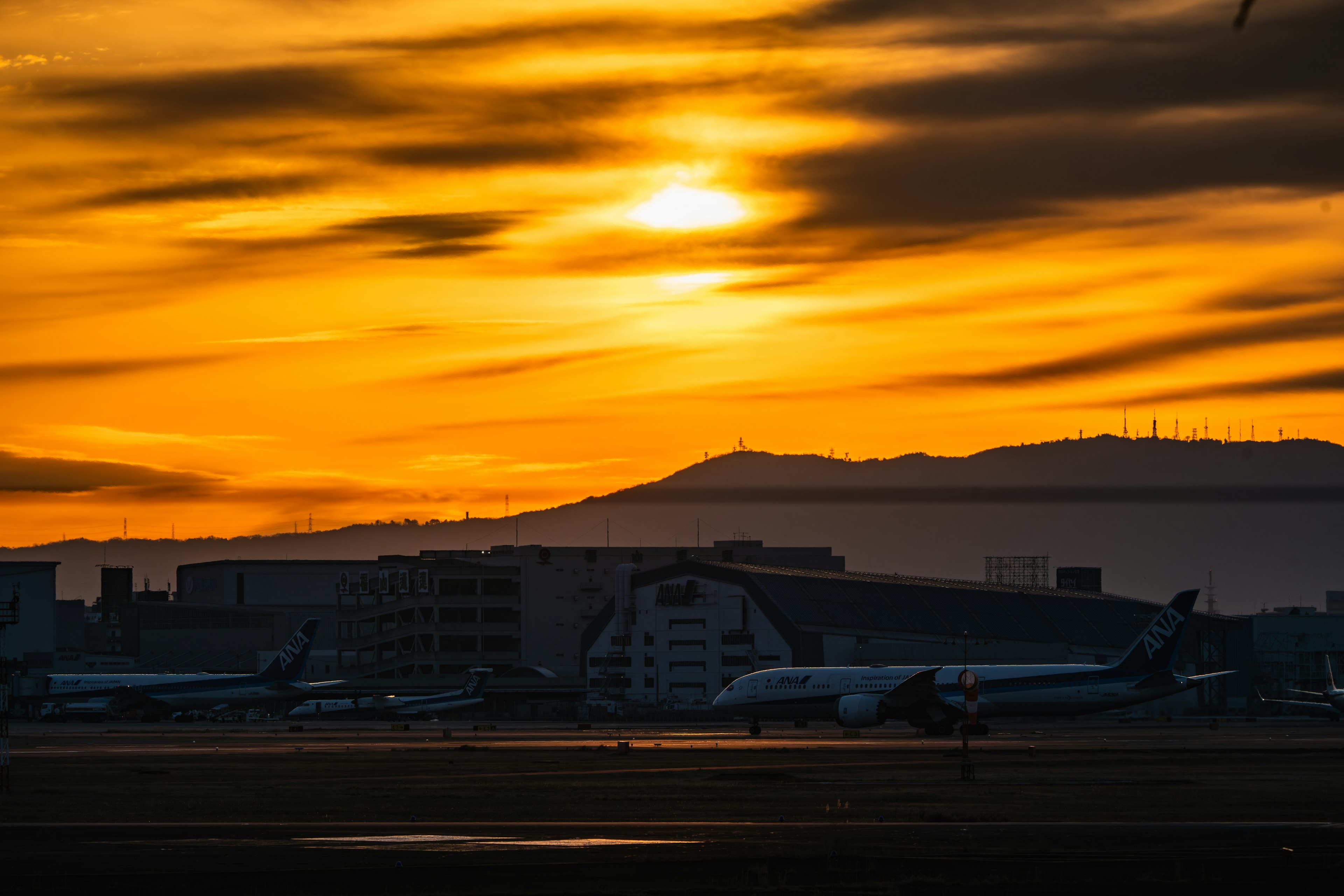 空港の夕日と飛行機のシルエット