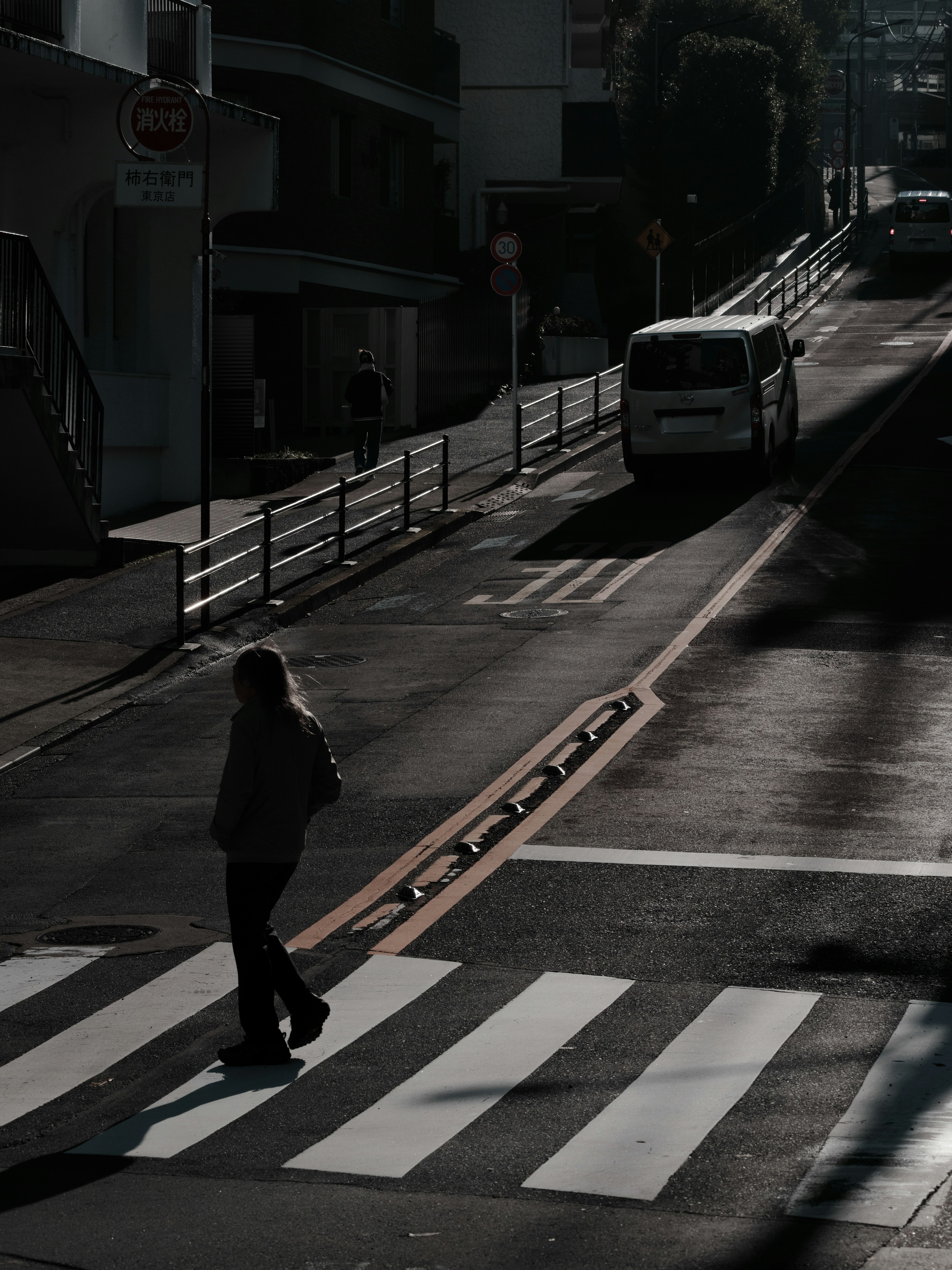 暗い通りを渡る人と車があるシーン