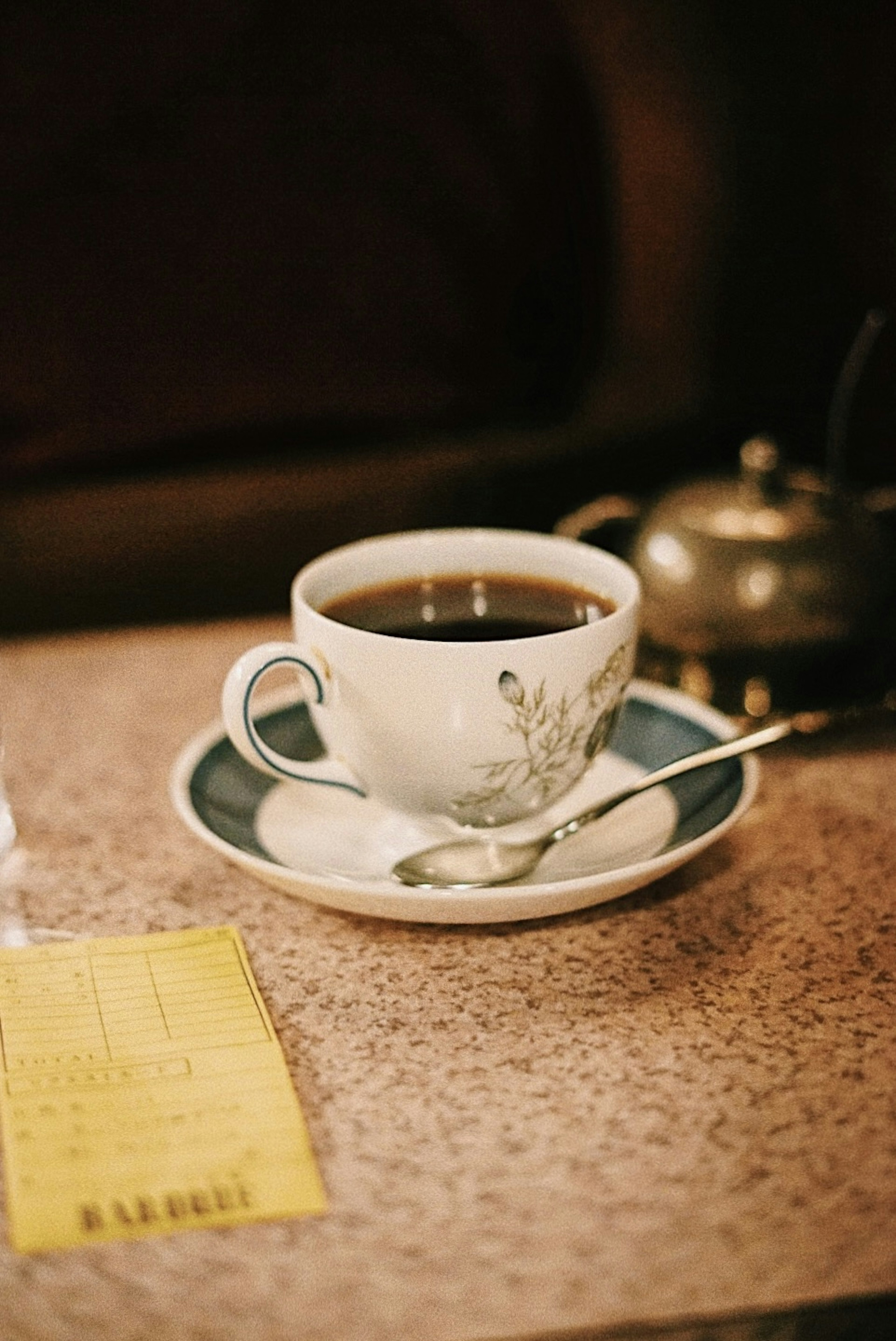 Una tazza bianca di caffè su un piattino su un tavolo