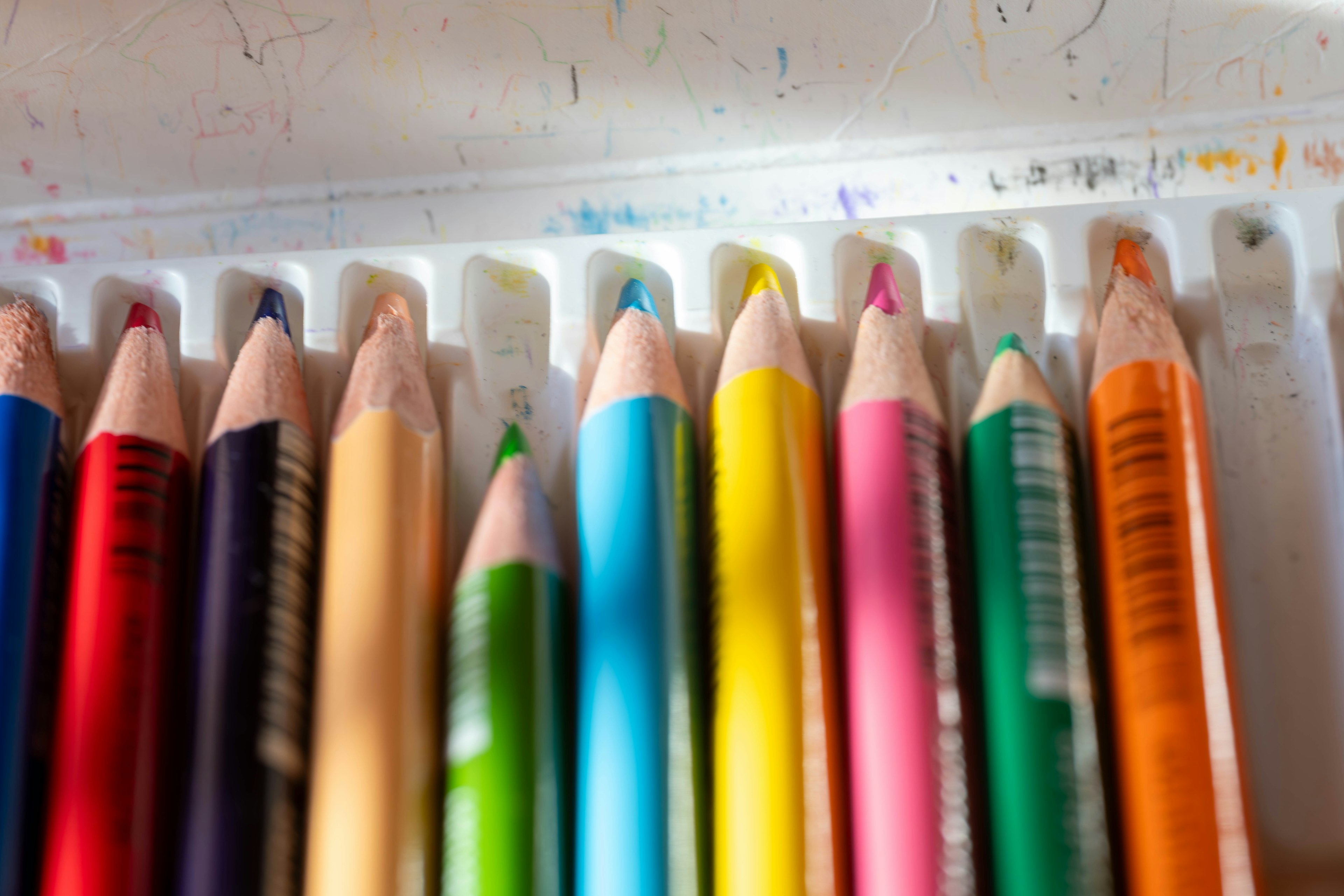 A close-up of colorful colored pencils arranged in a tray