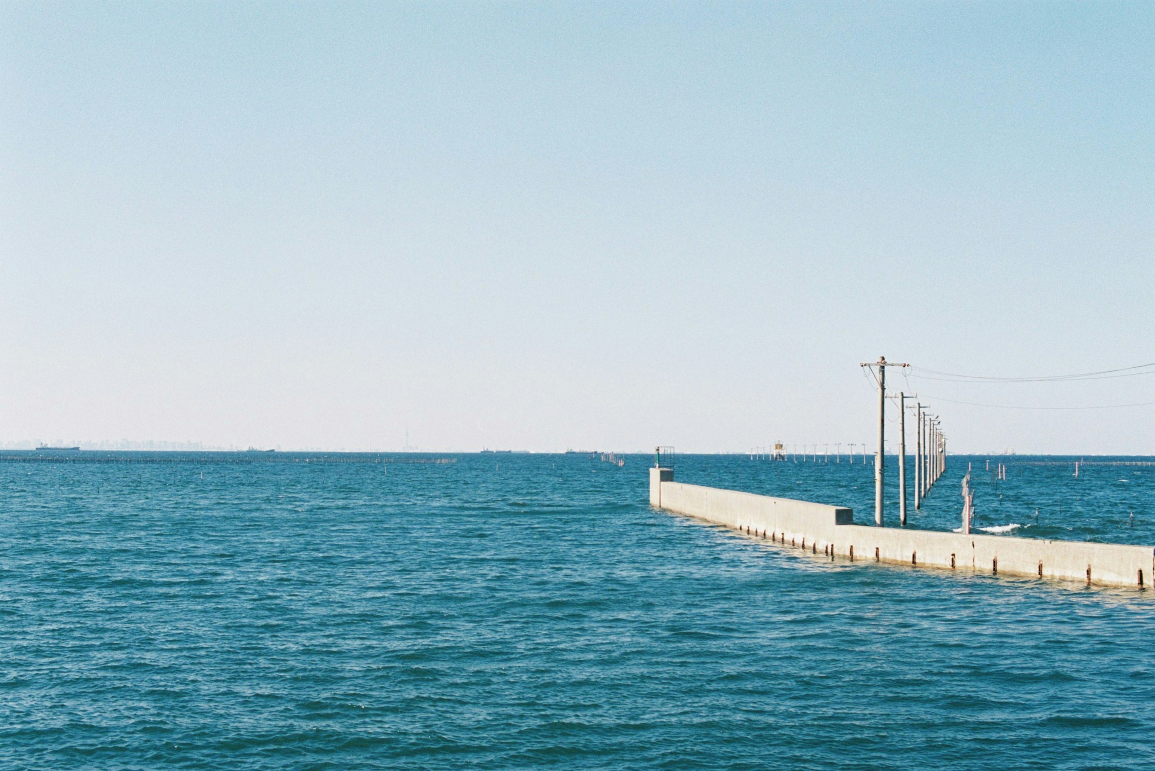 View of a blue sea with a pier