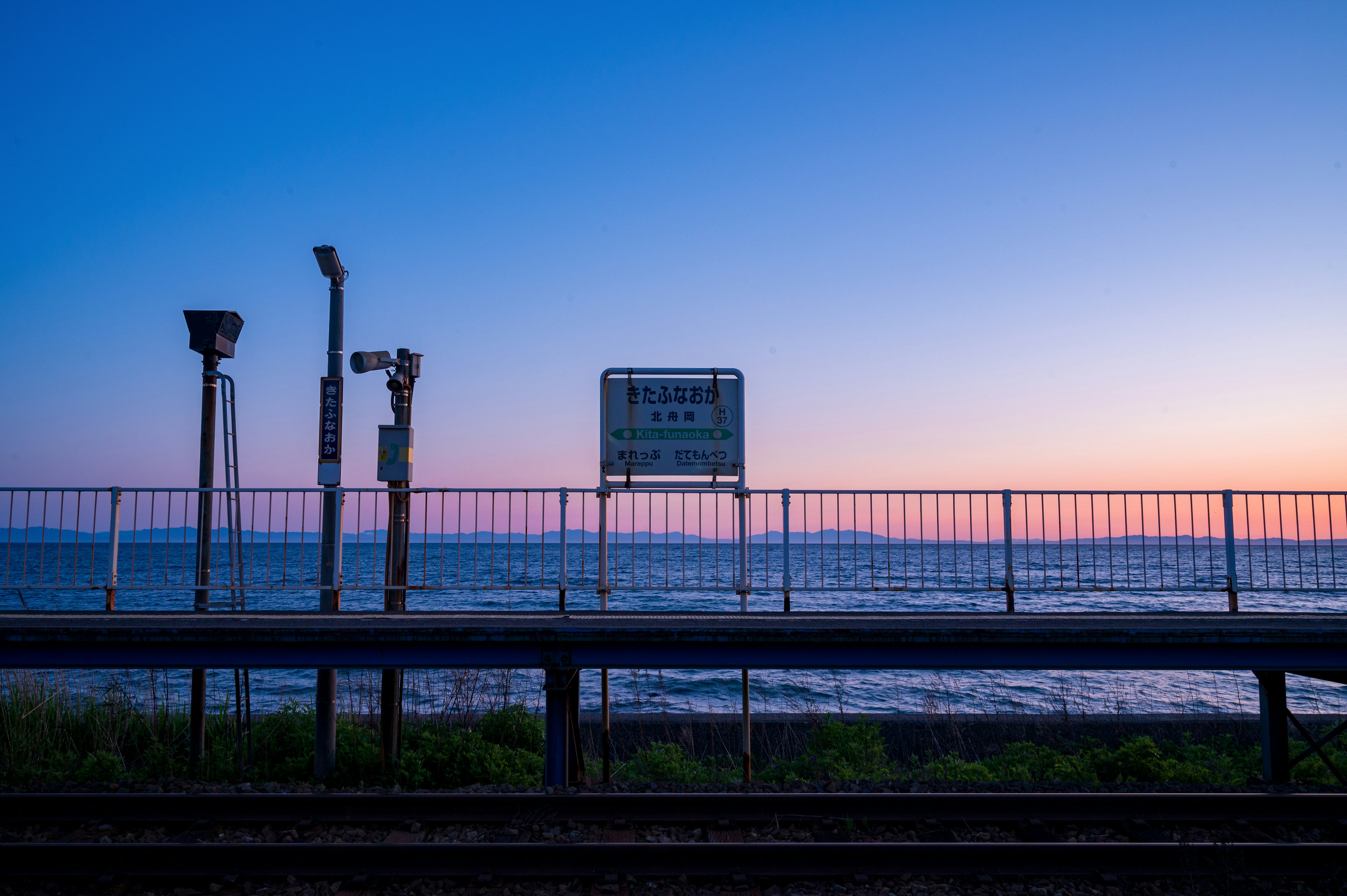 鐵路車站景觀，背景為海洋和日落