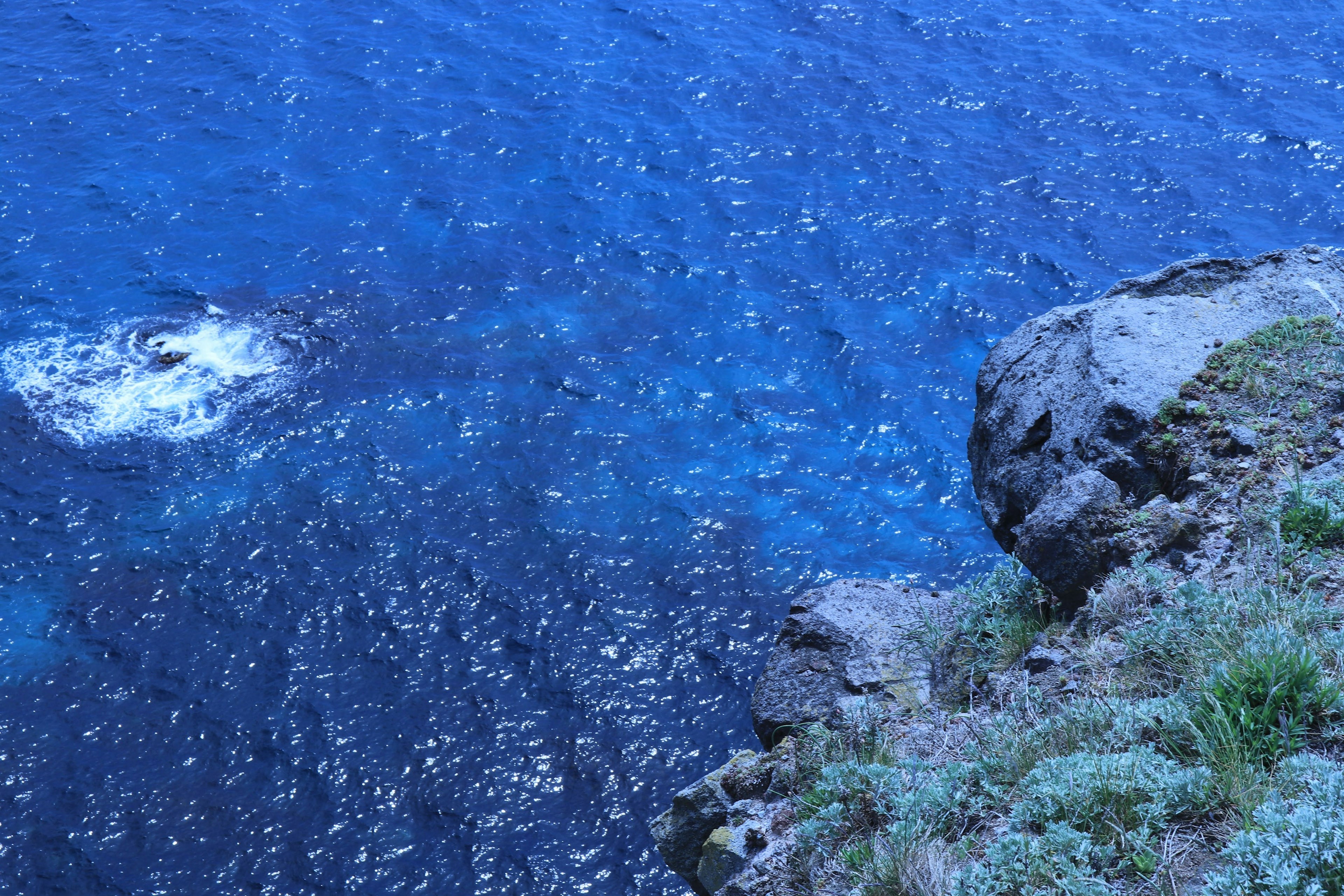 Pemandangan laut biru dan tebing berbatu