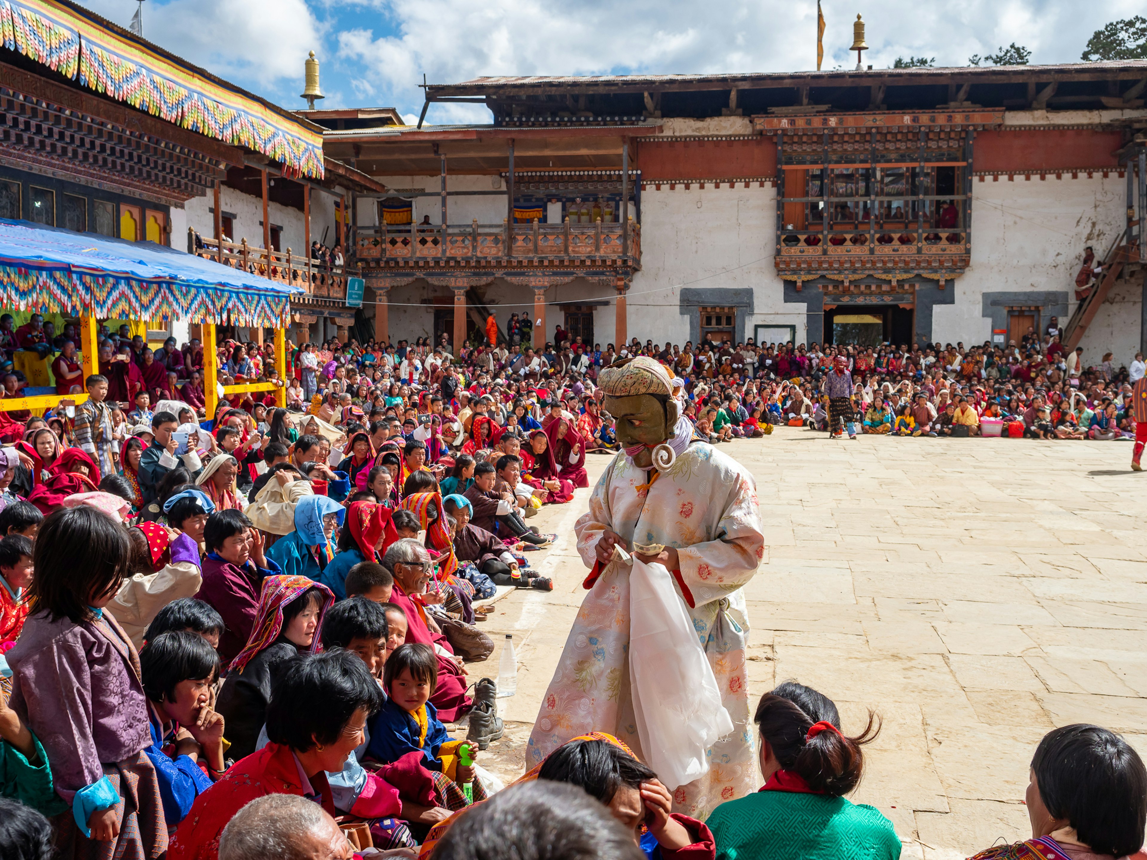 Crowd gathered for a festival with performer in traditional attire