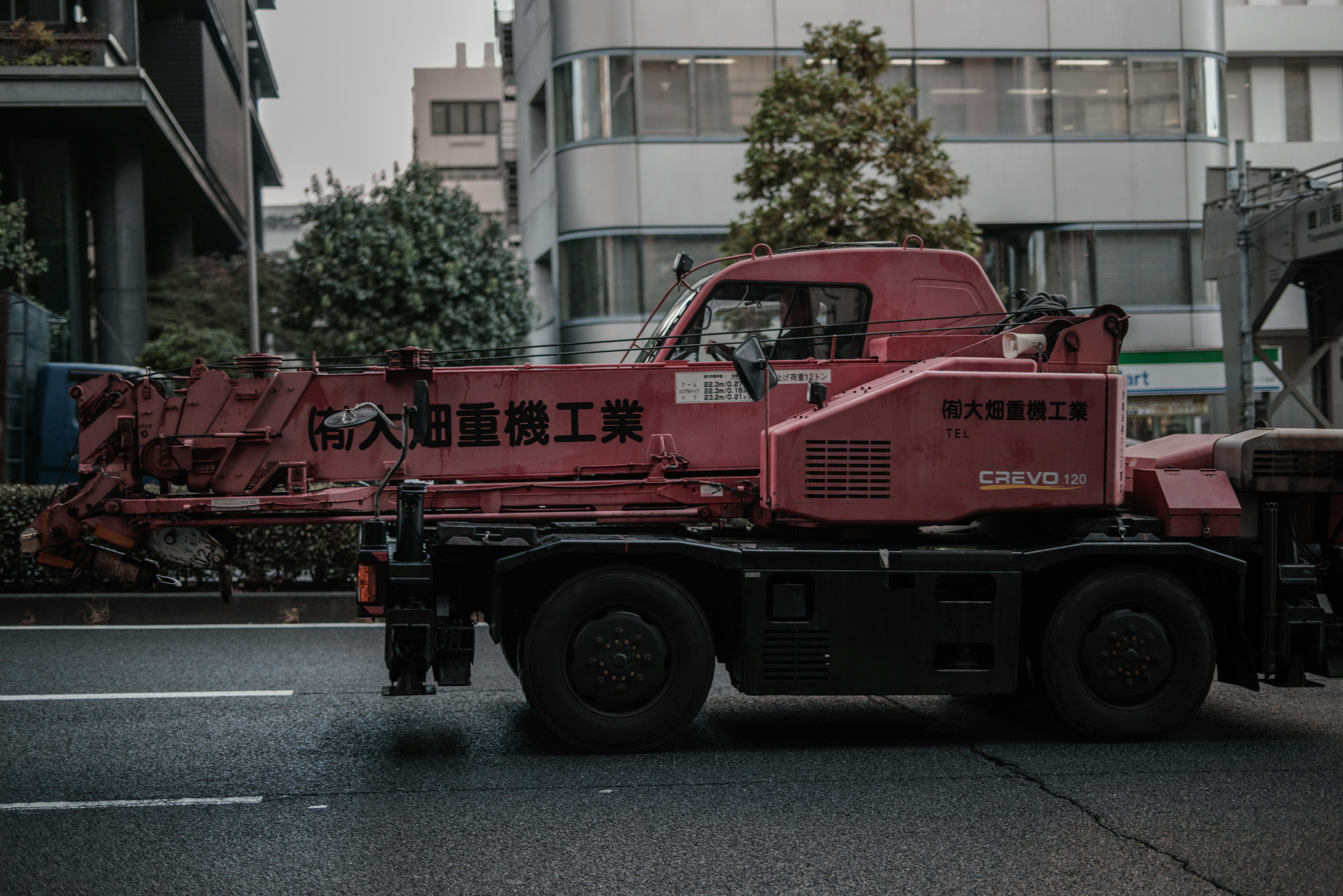 Red crane truck driving through the city