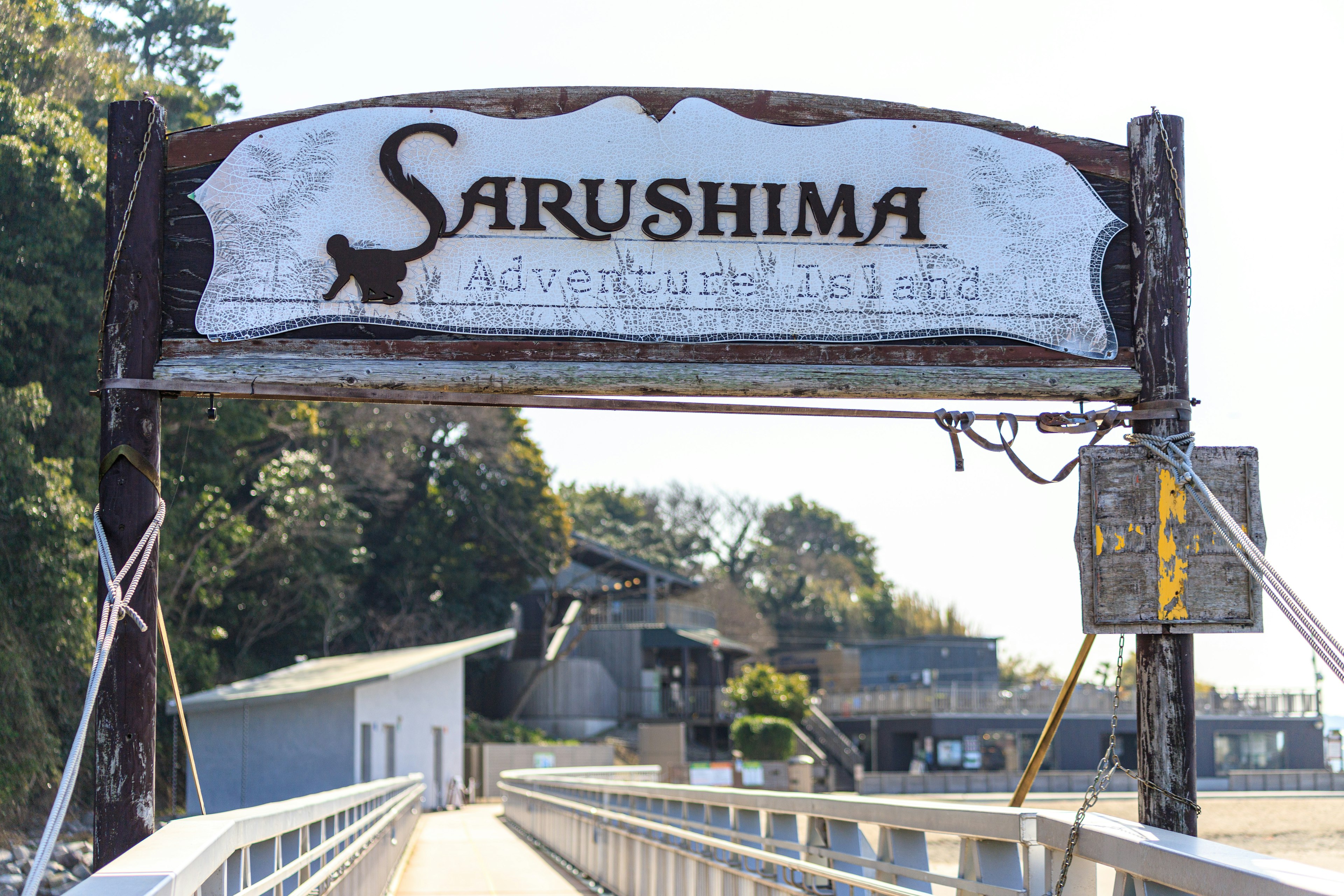 Insegna di Sarushima su un molo con alberi sullo sfondo