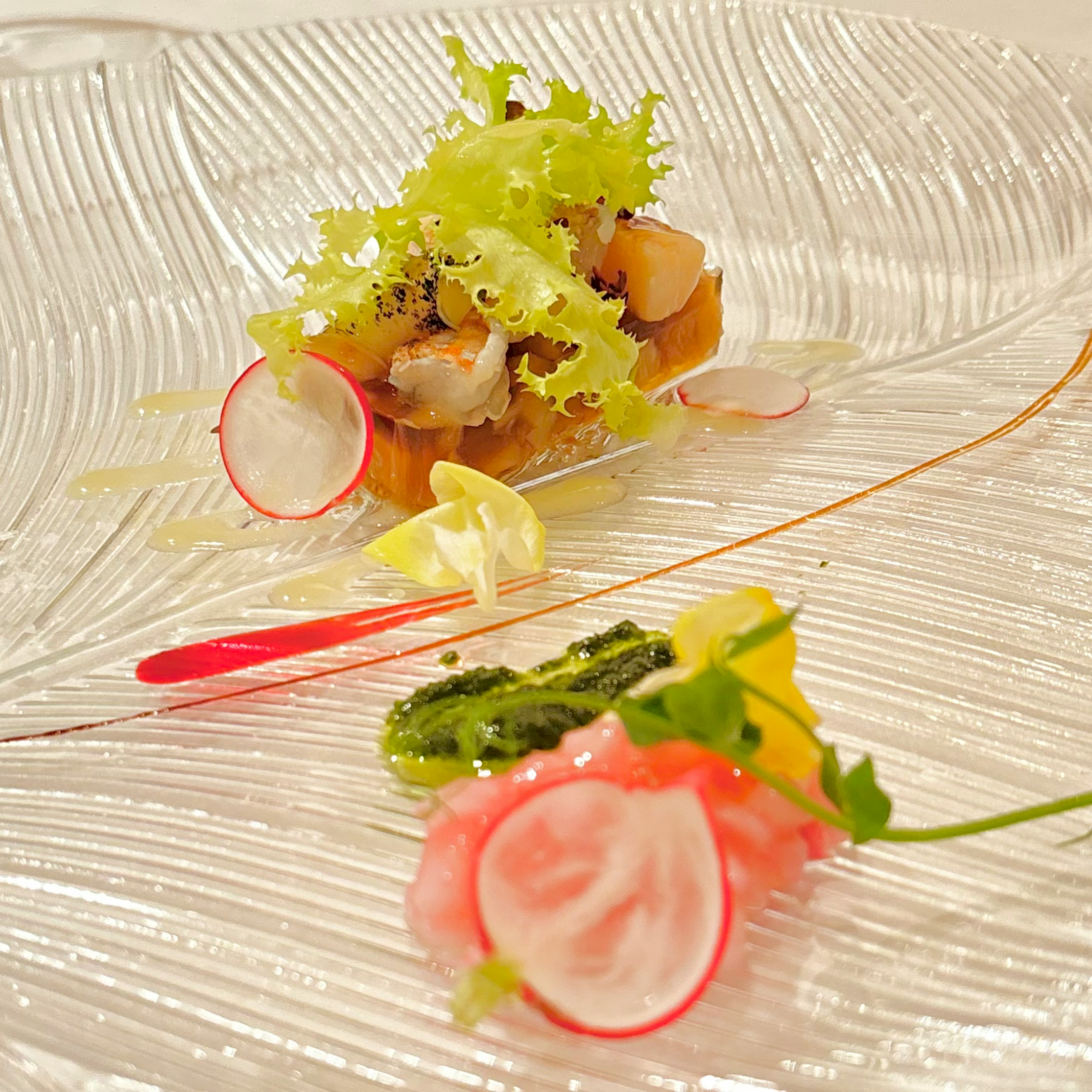 A beautifully plated appetizer dish featuring fresh vegetables and seafood