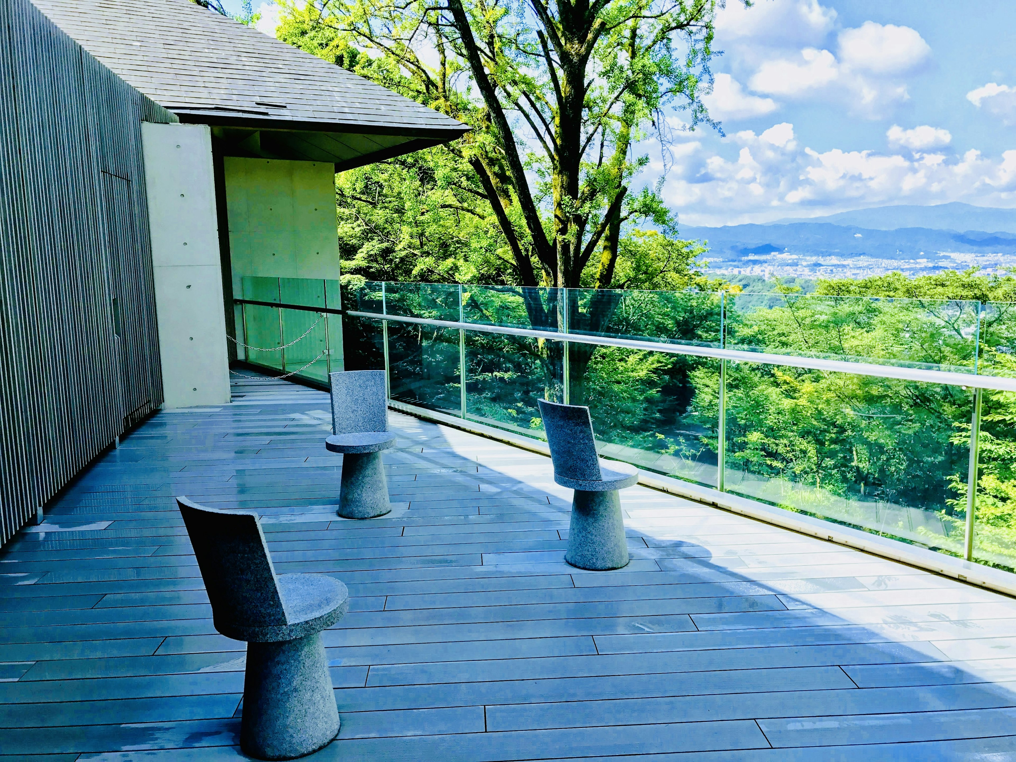 Stilvolle Stühle auf einer Terrasse mit Blick auf eine grüne Landschaft