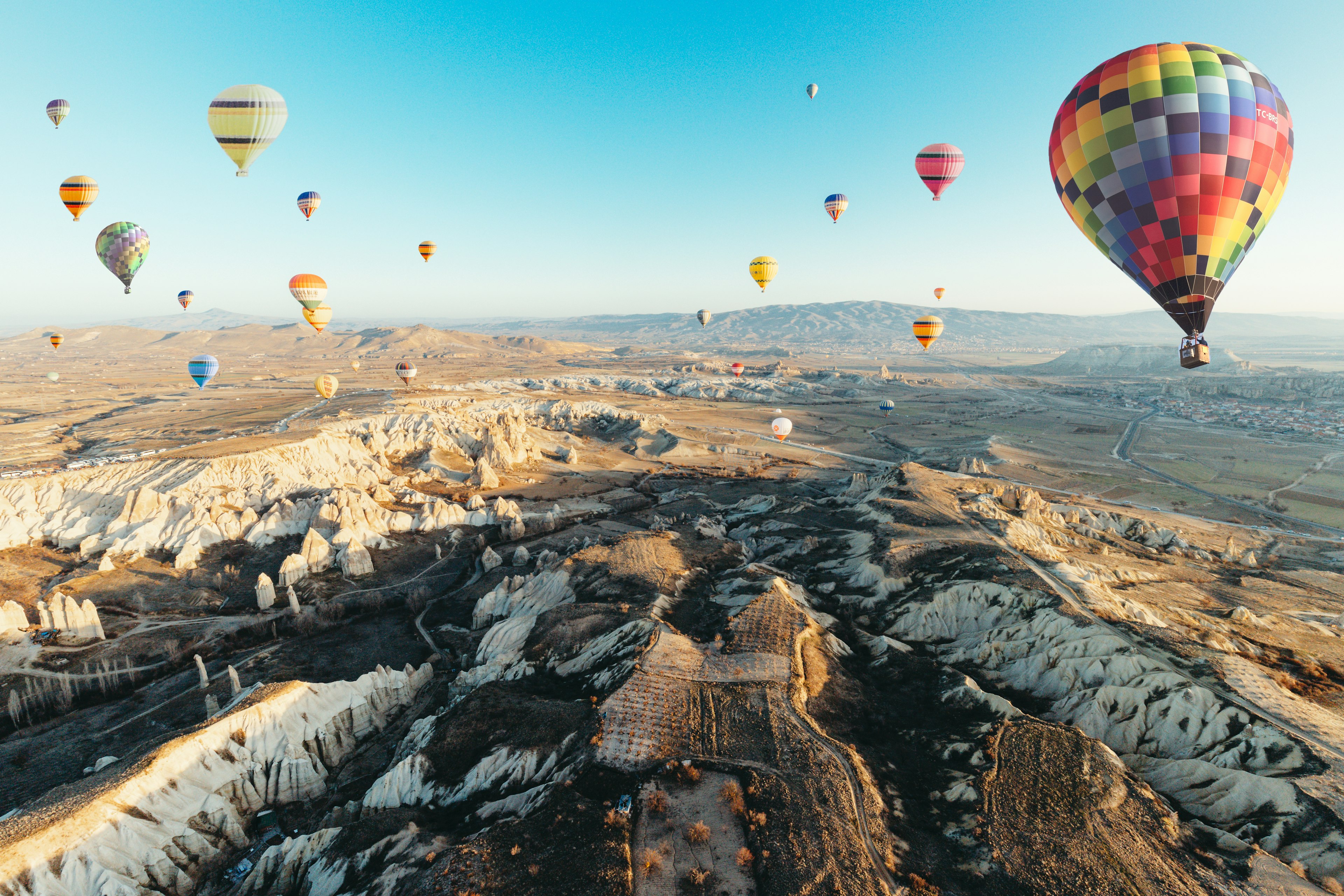 Balon udara berwarna-warni mengapung di atas lanskap Cappadocia