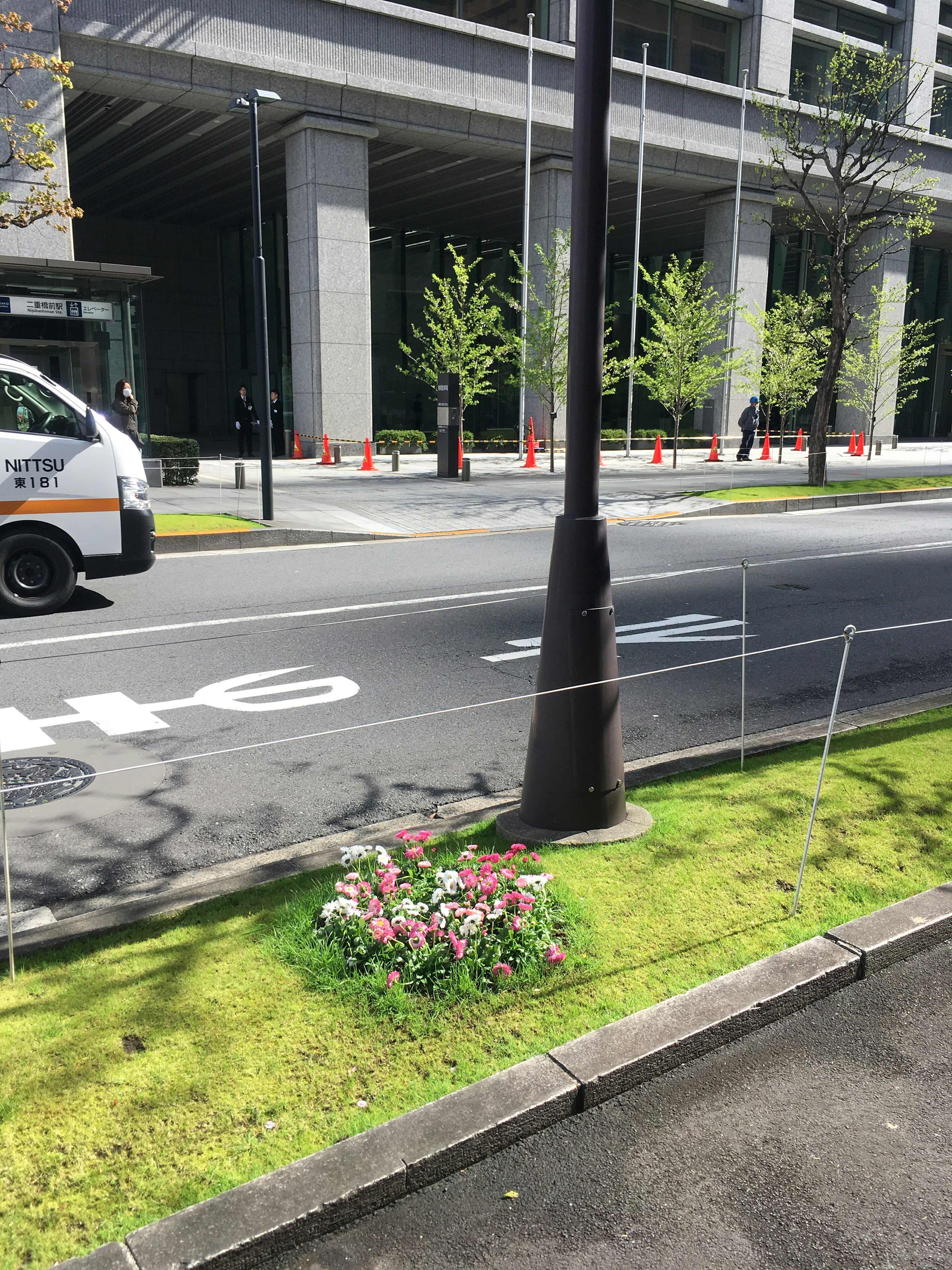 Städtische Szene mit Blumenbeet und Straßenlaterne entlang der Straße