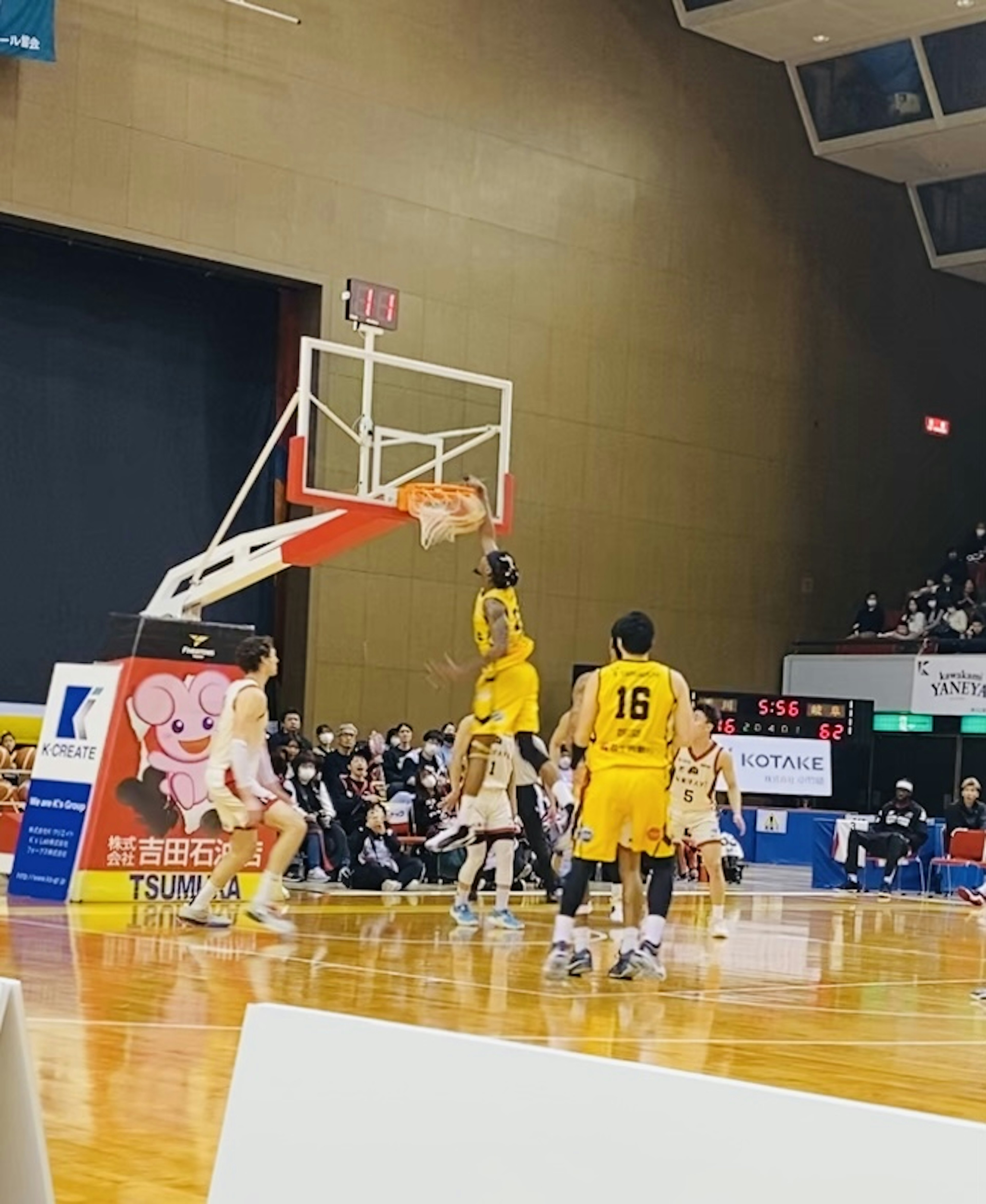 Seorang pemain basket melakukan slam dunk selama pertandingan