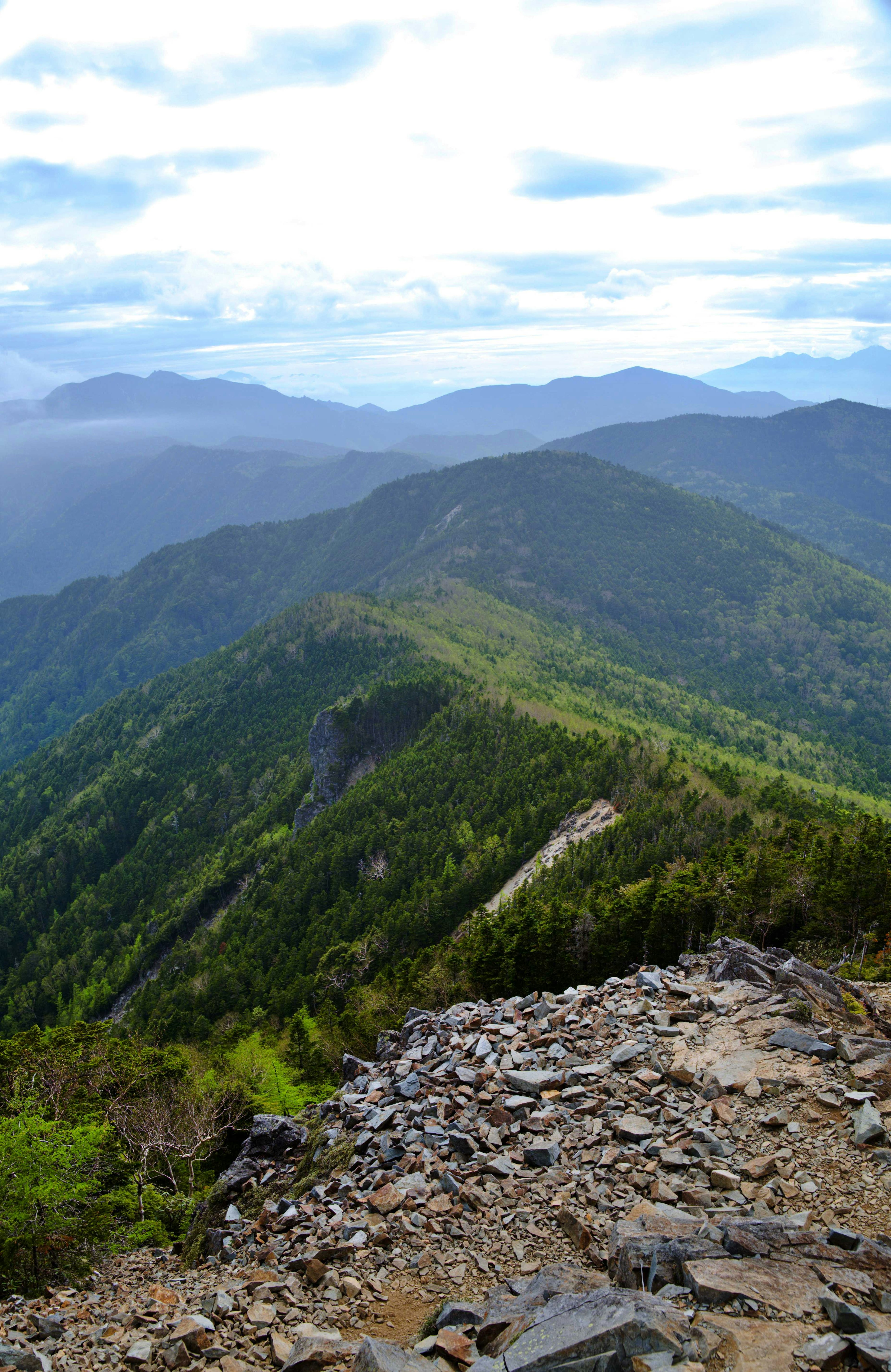 Vue panoramique sur des montagnes verdoyantes sous un ciel bleu