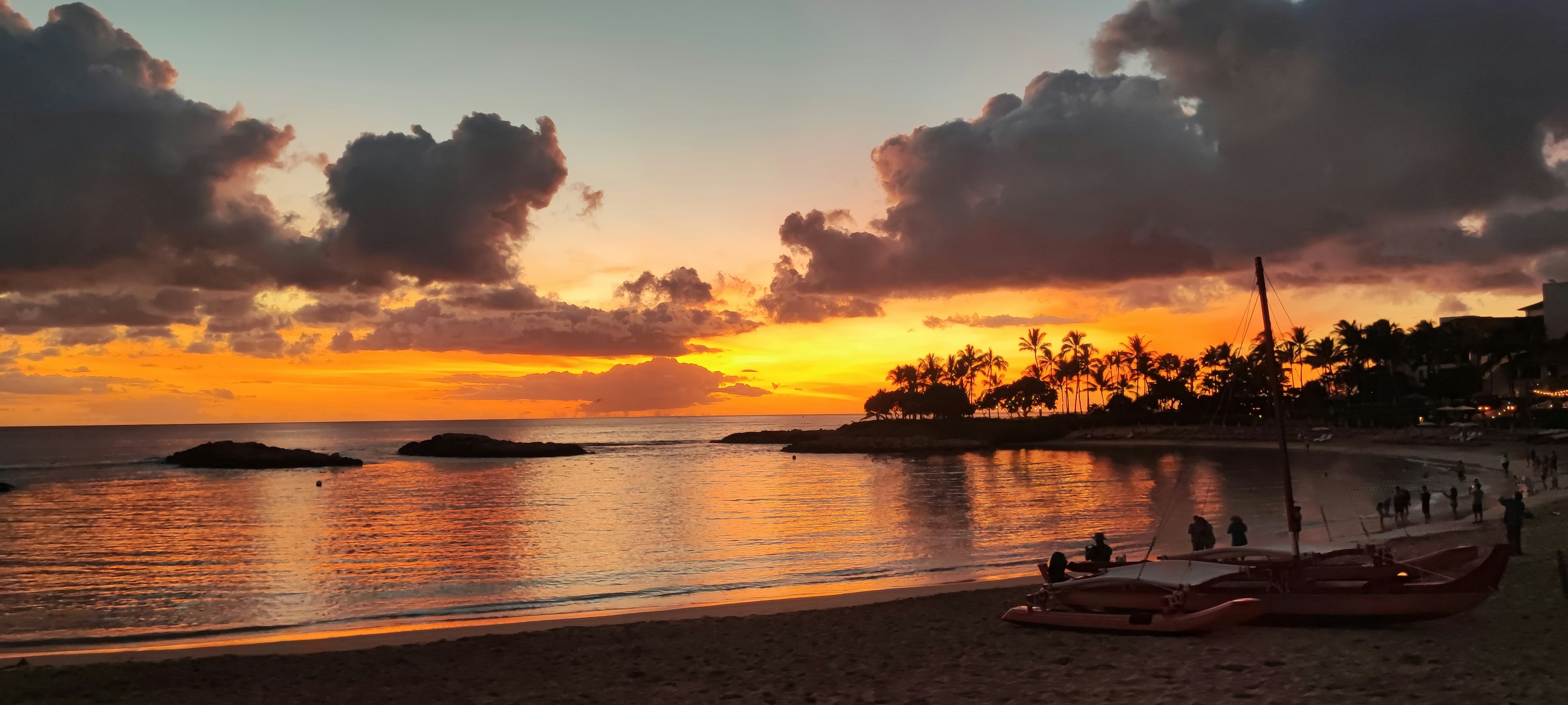 Beautiful beach scene with a sunset reflecting on the water boats lined on the shore