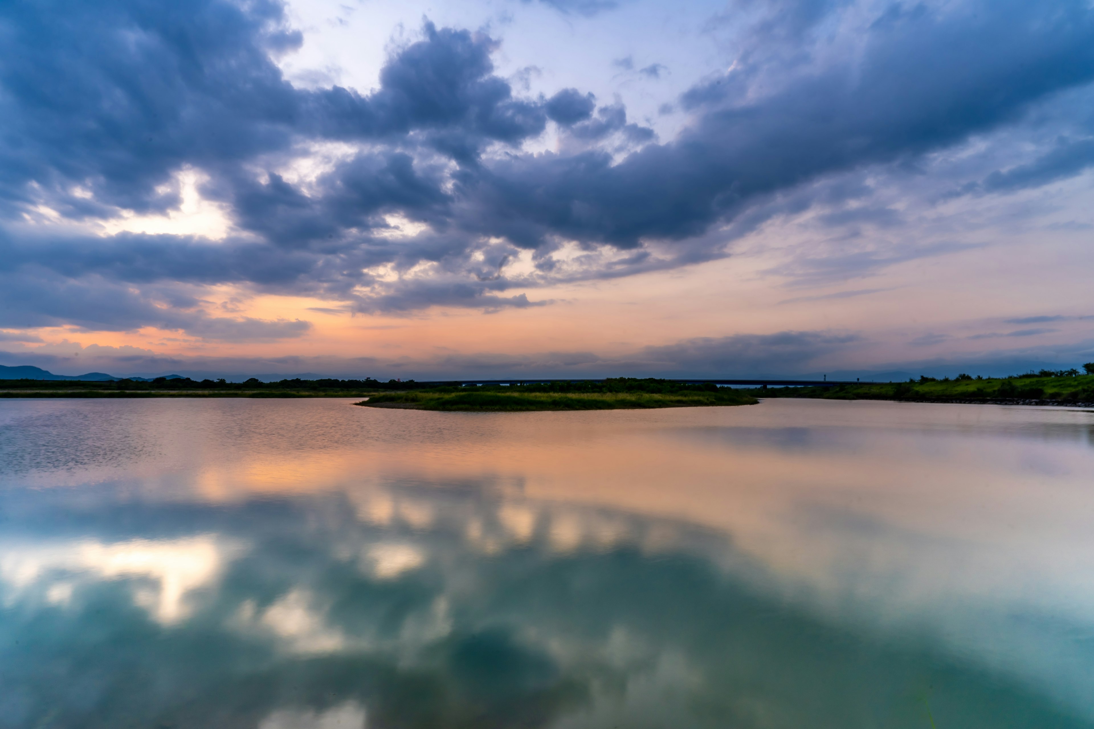 穏やかな水面に映る雲と空の色合いが美しい風景