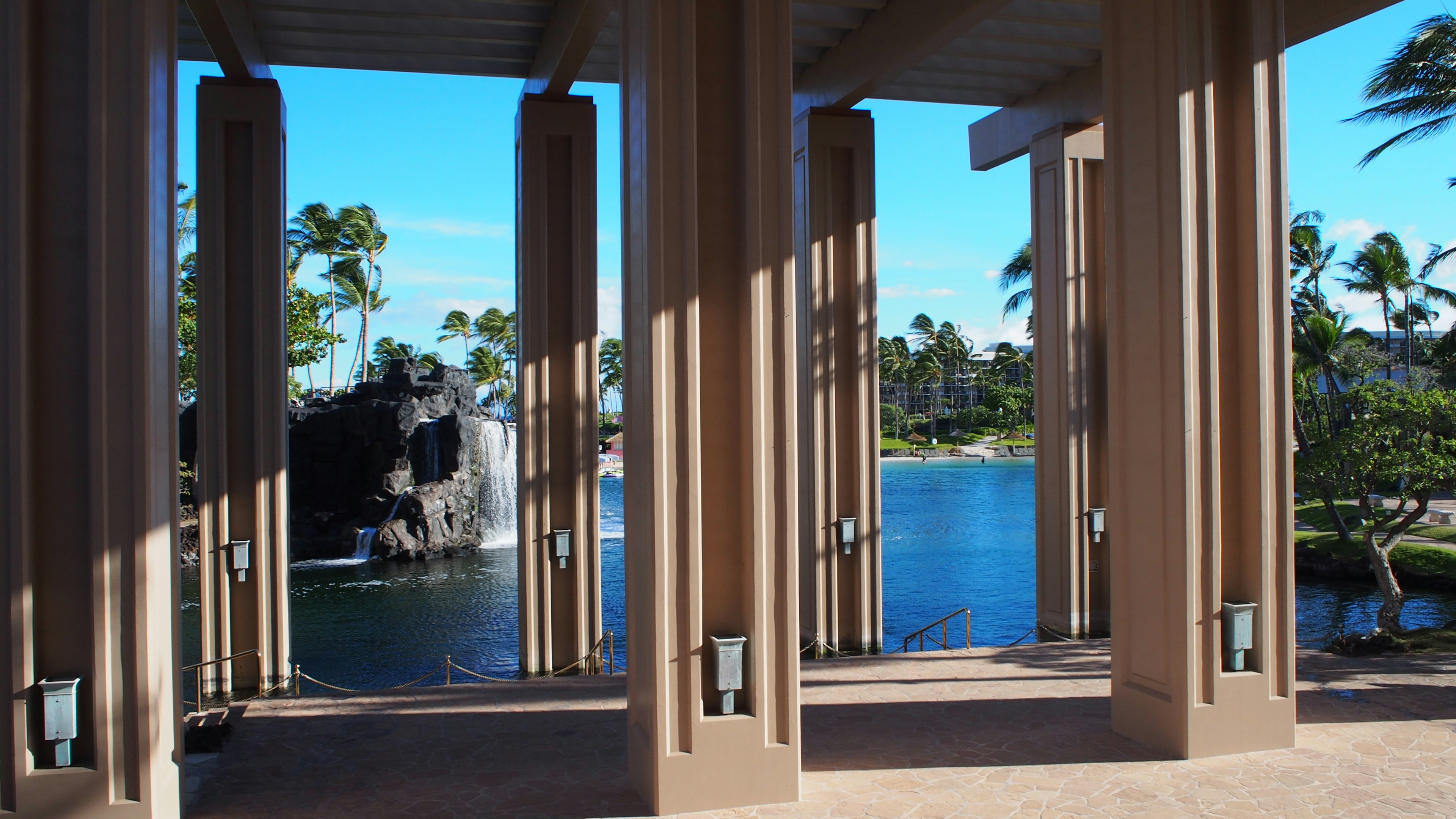 Open space with pillars and a blue lake in the background