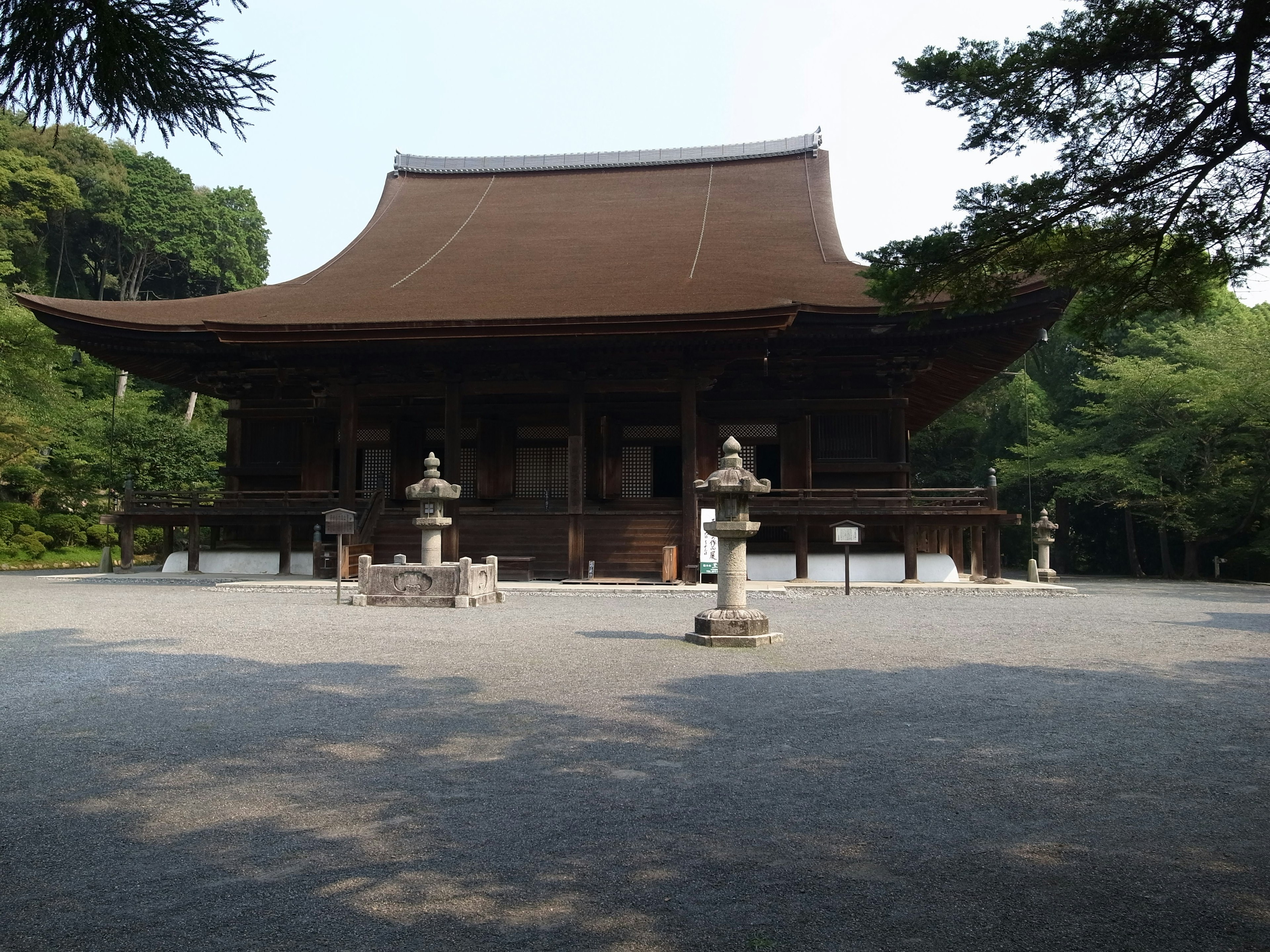 Extérieur d'un temple japonais traditionnel entouré de verdure dans un cadre tranquille