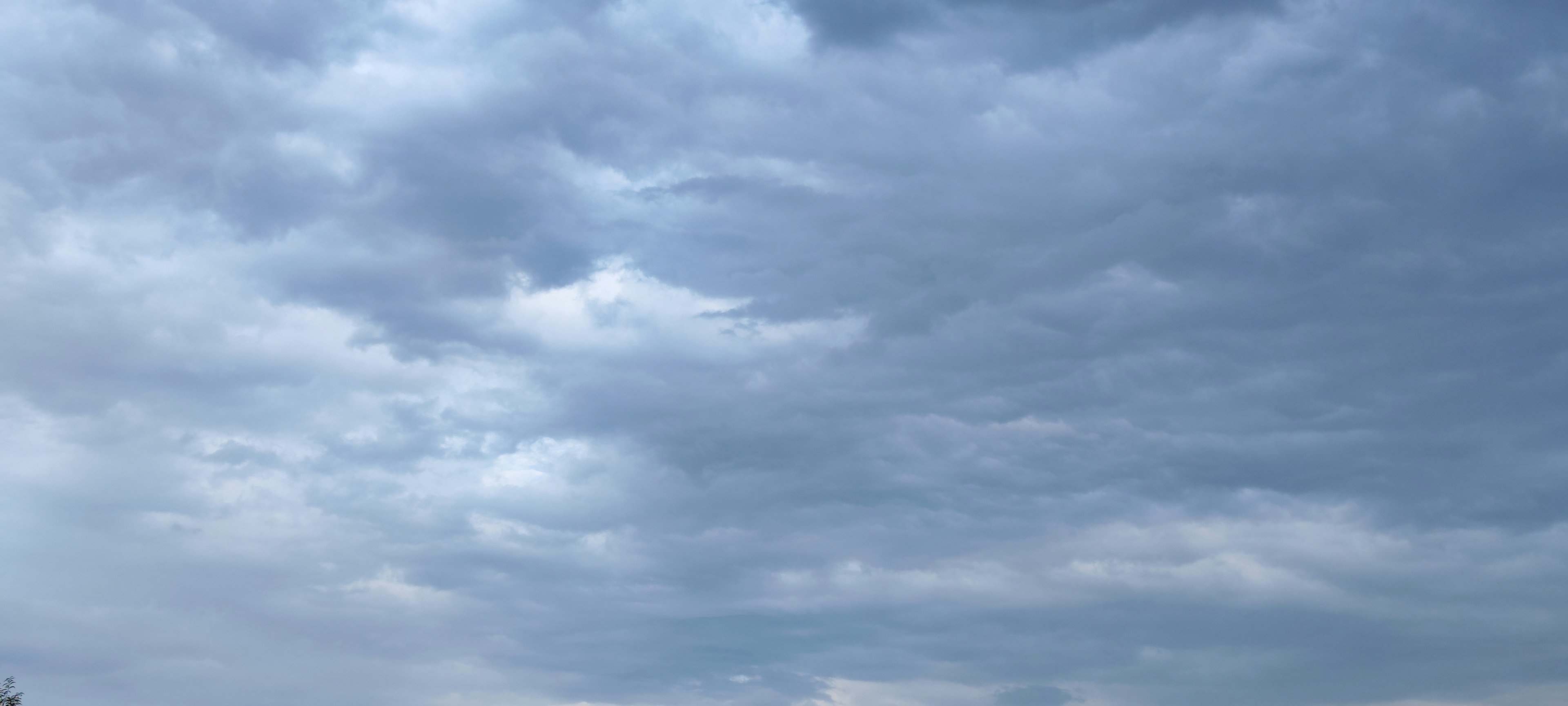 Épaisses nuages s'étendent à travers un ciel bleu