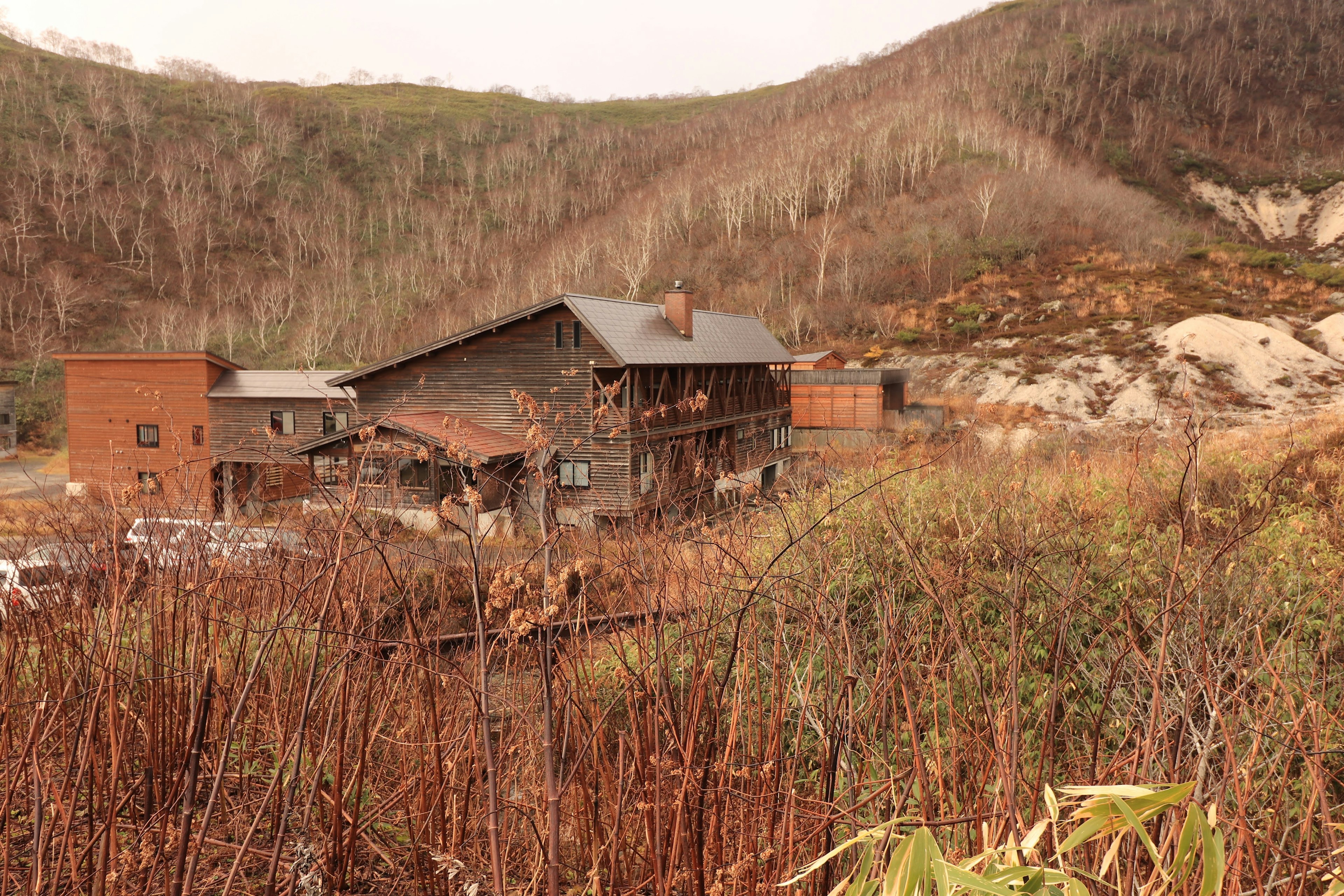 Abandoned buildings surrounded by dry vegetation in a mountainous area