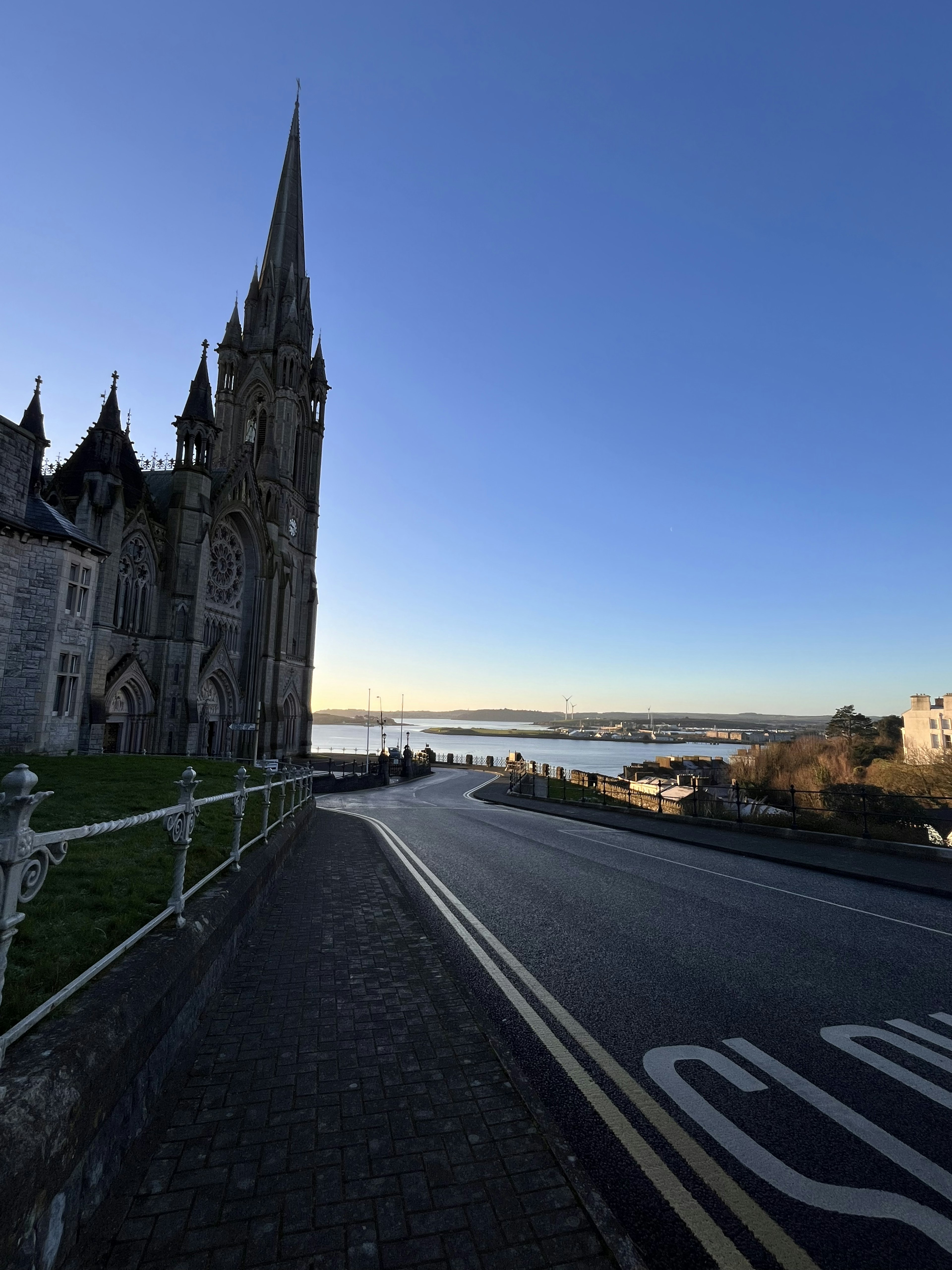 Église de style gothique sous un ciel bleu avec une route sinueuse