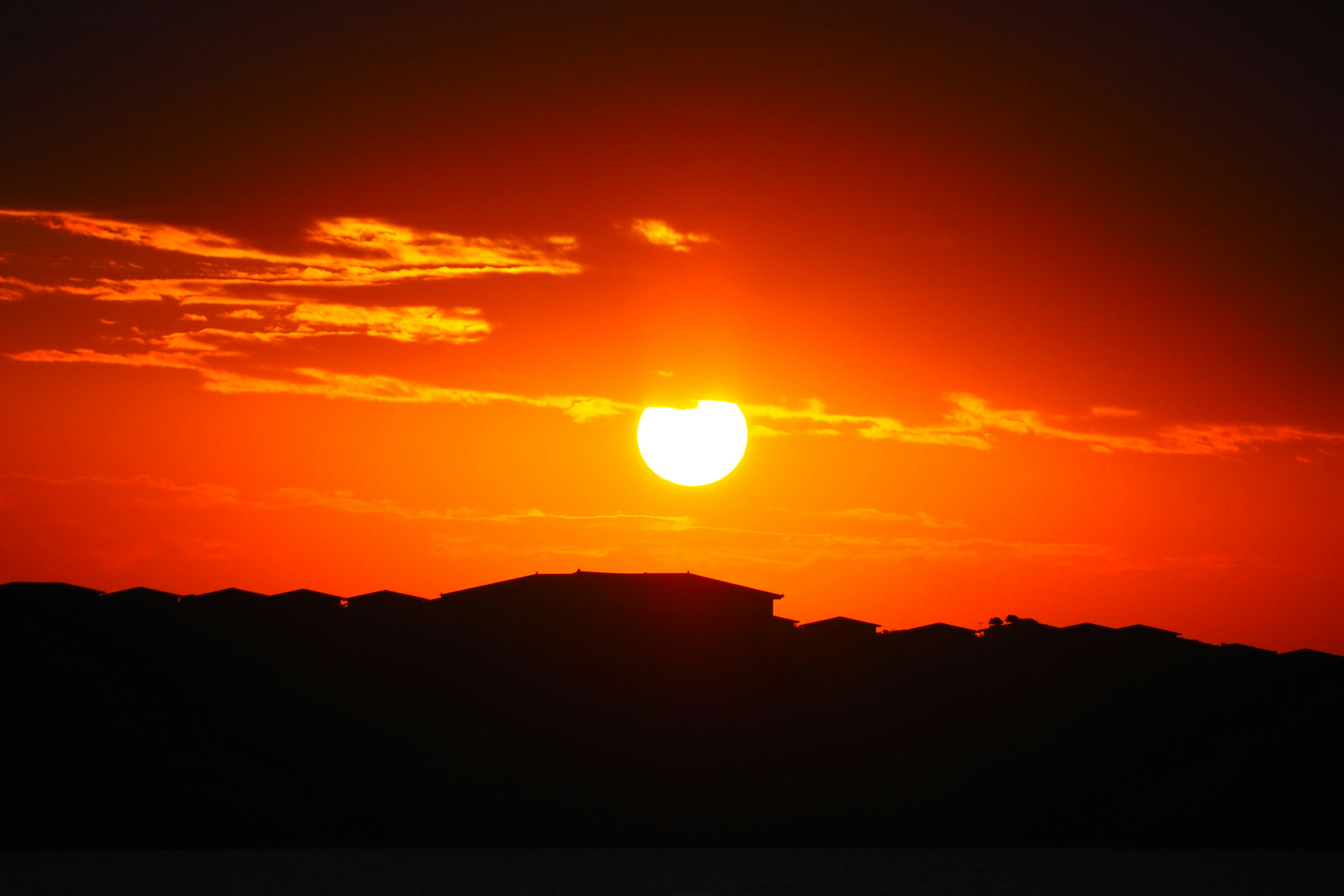 Sonnenuntergang mit silhouettiertem Gebäude und orangefarbenem Himmel