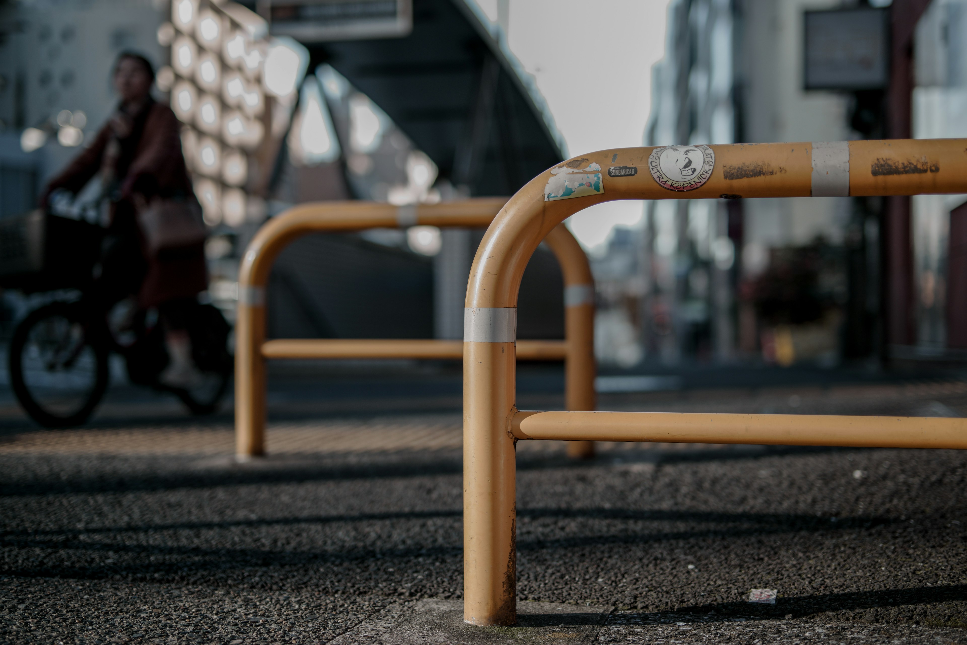 Orange barriers in an urban setting with a cyclist in the background