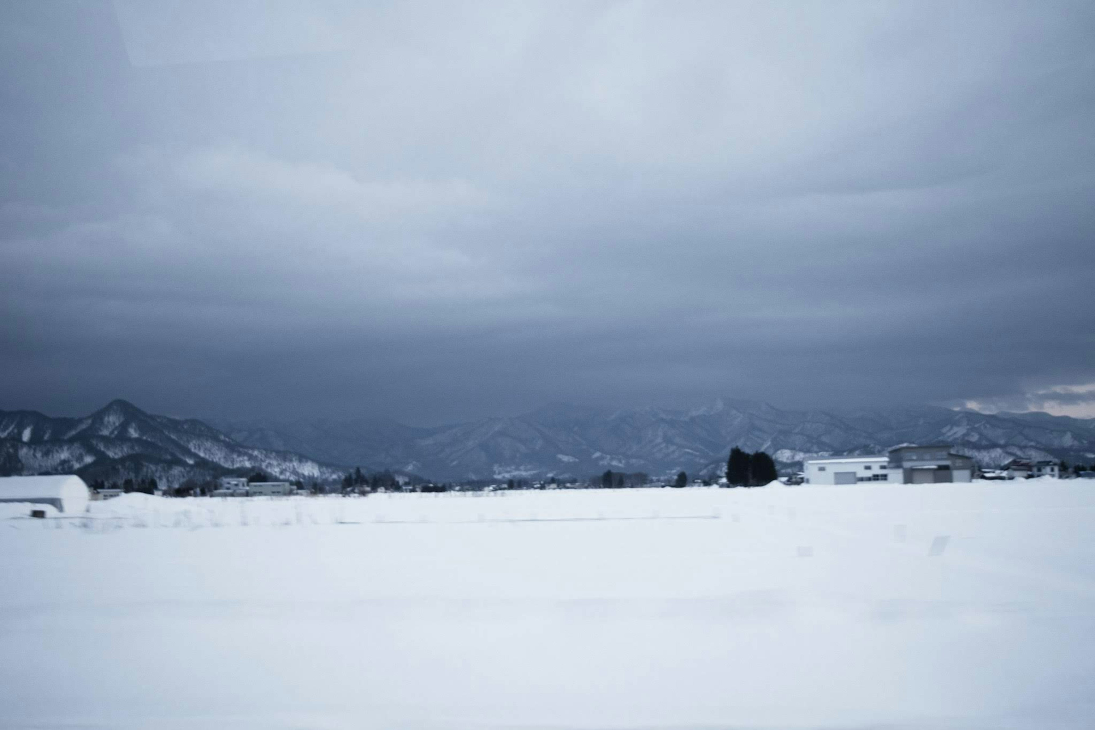 Snow-covered landscape with dark clouds in the sky