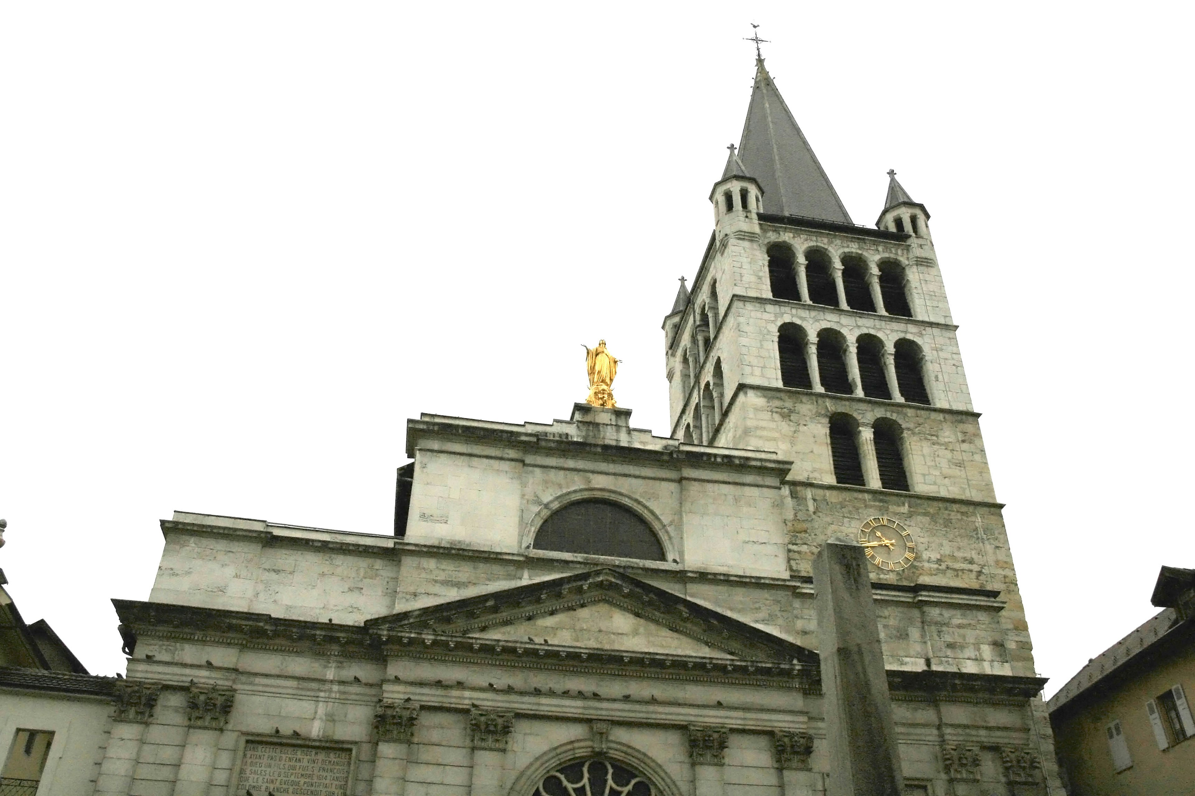 Historisches Gebäude mit Kirchturm und goldener Statue