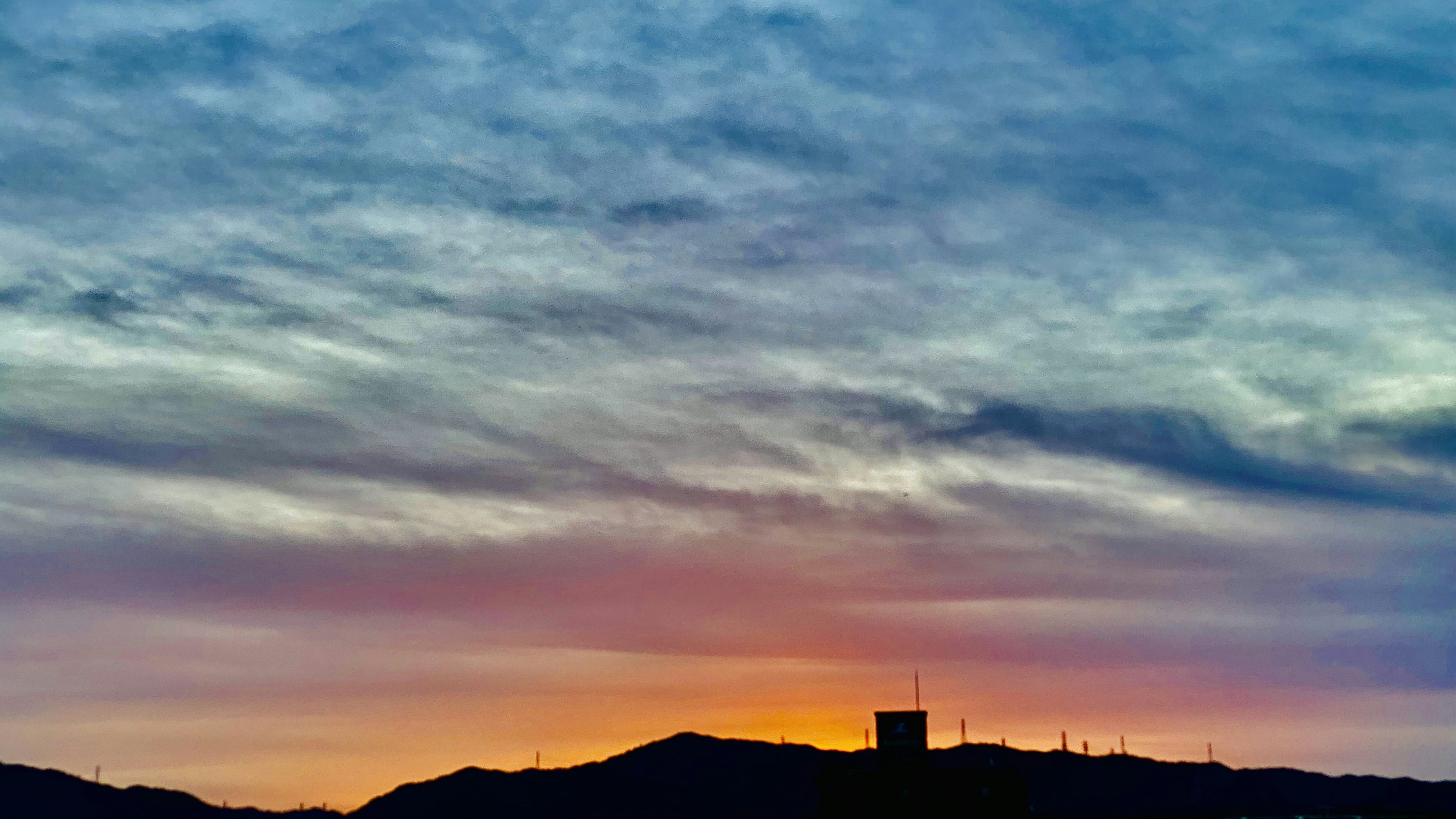 Schöner Sonnenuntergangshimmel mit silhouettierten Bergen