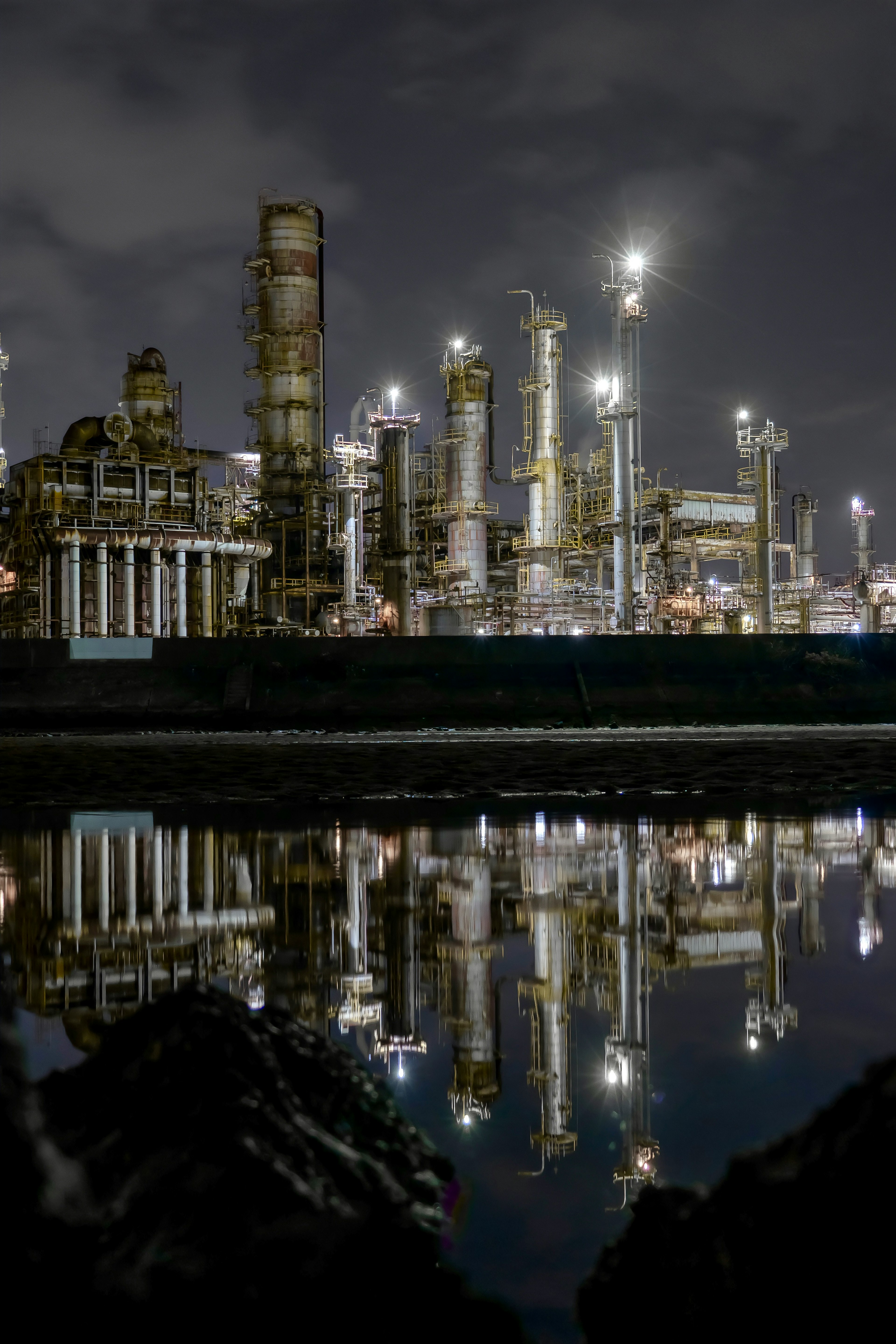 Night view of an industrial complex with lights reflecting on water