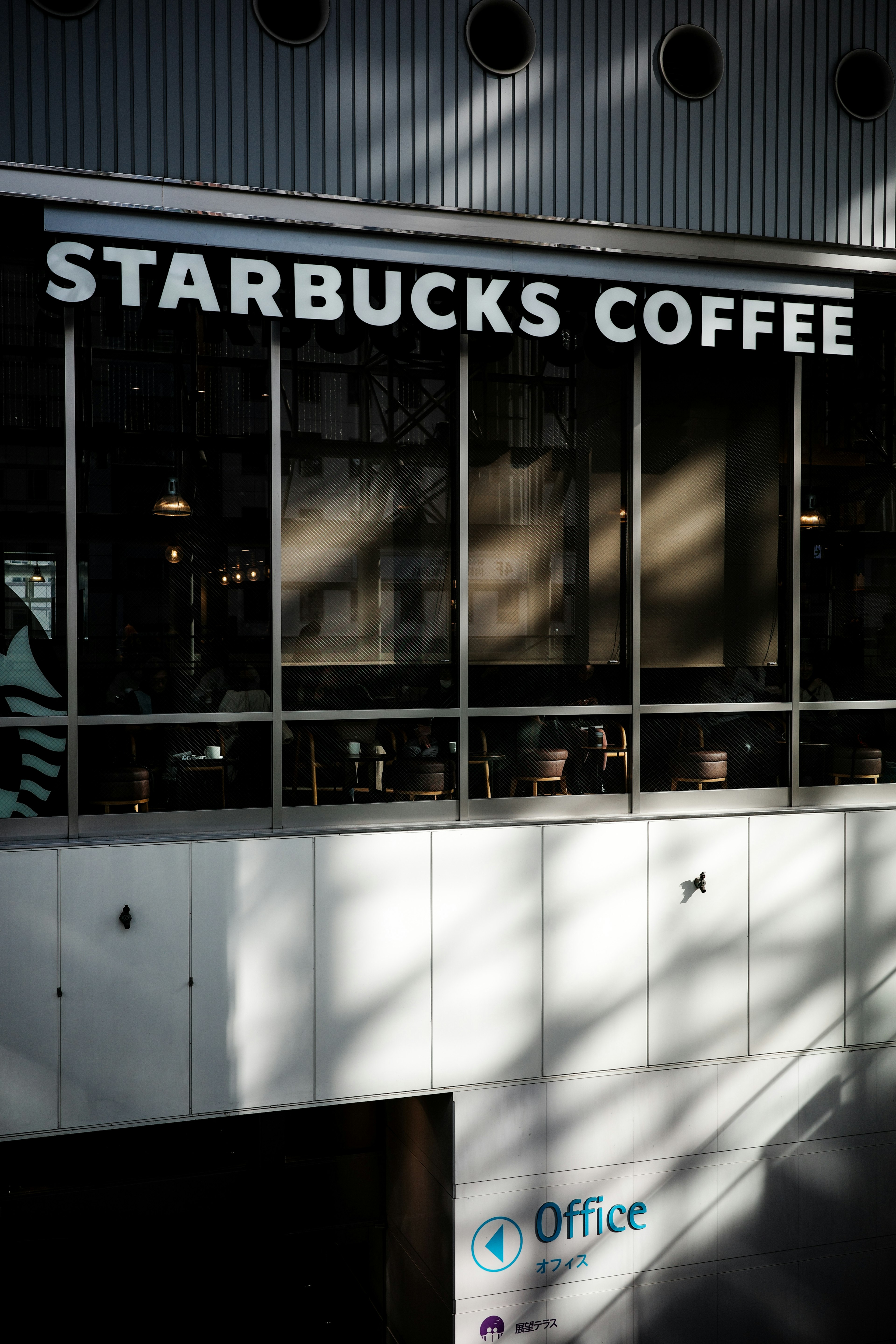 Vue extérieure de Starbucks Coffee avec une grande enseigne et des fenêtres en verre