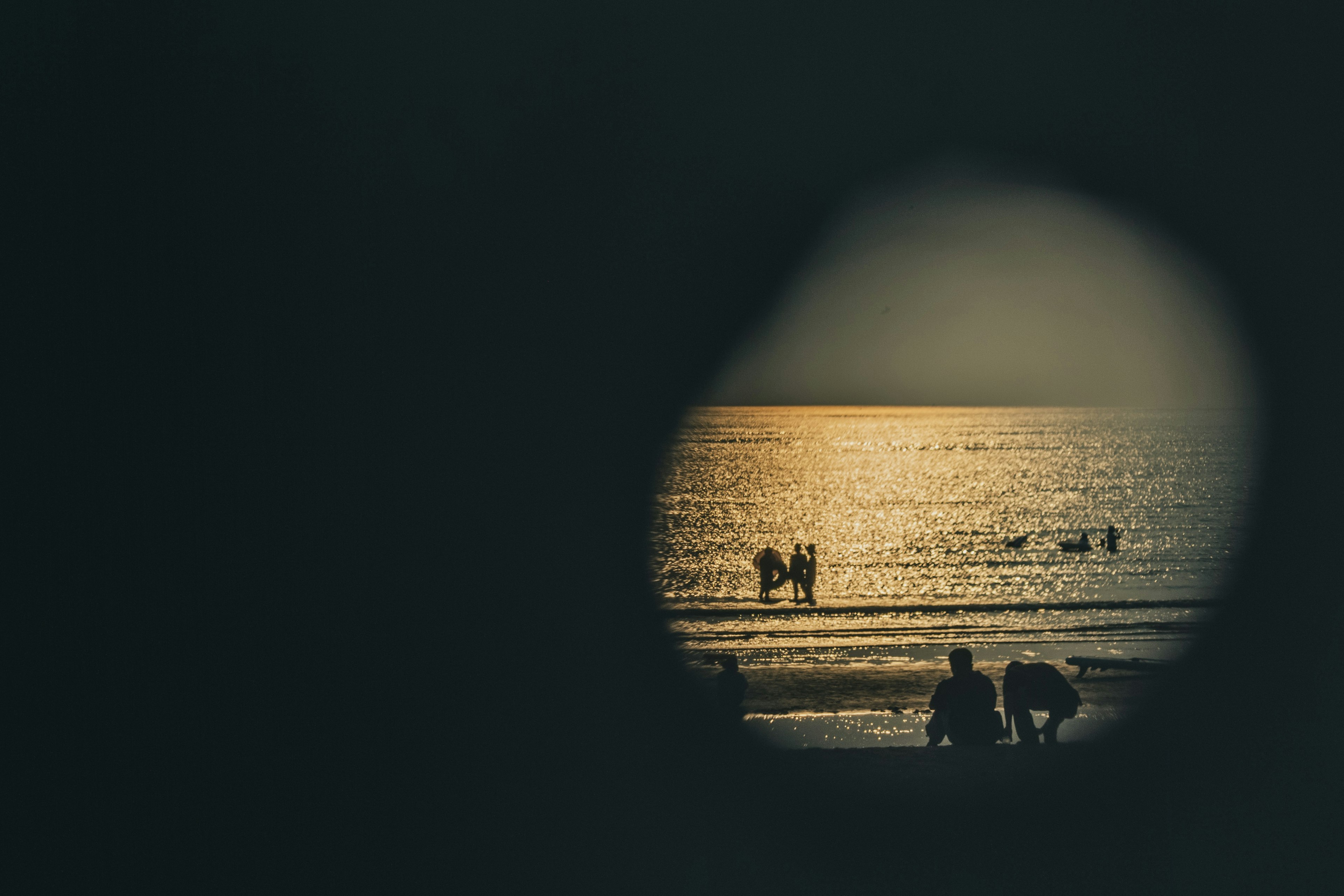 Siluetas de personas en la playa con una hermosa puesta de sol sobre el océano