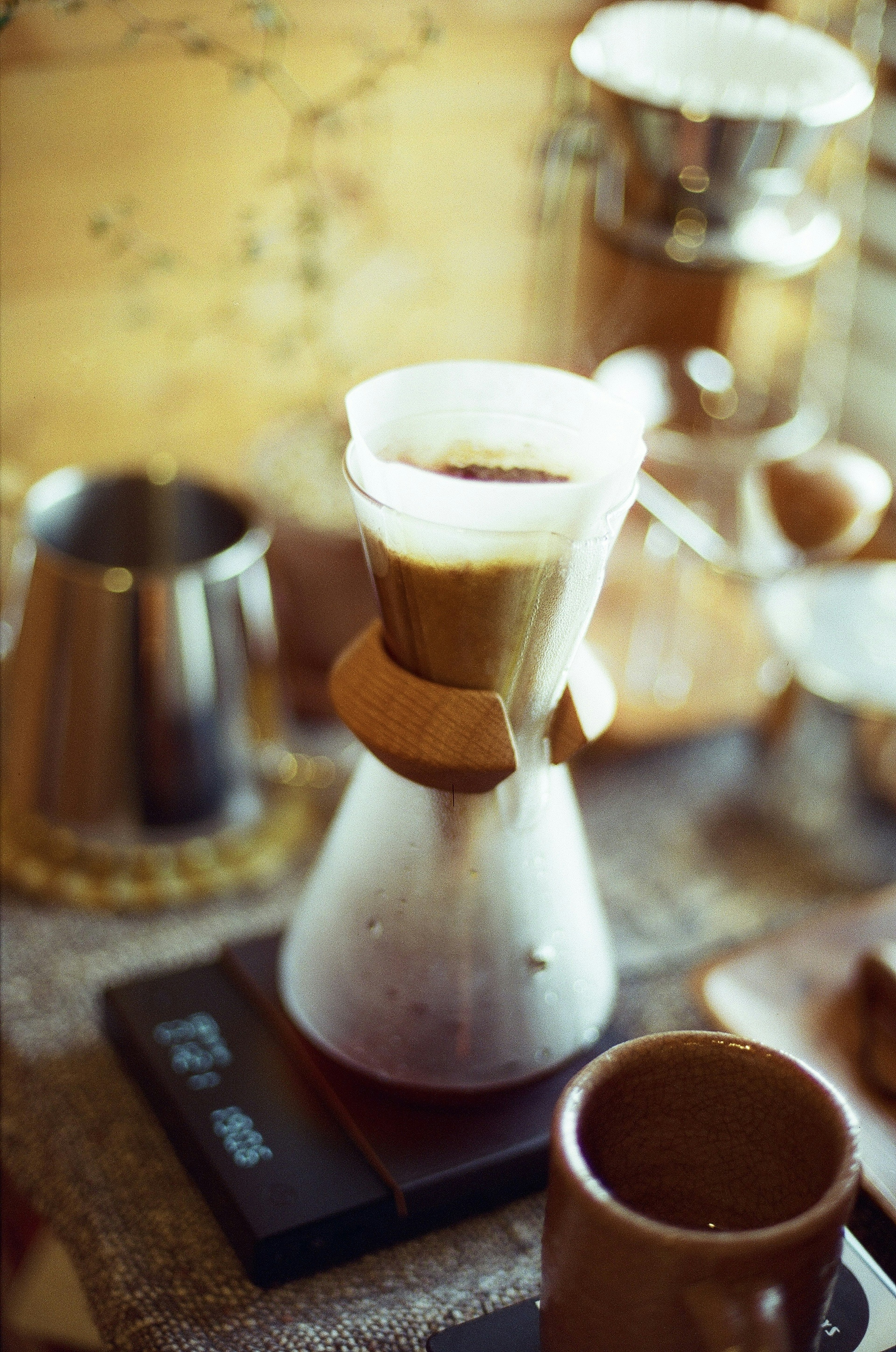 Pengaturan penyeduhan kopi dengan penyaring dan cangkir di atas meja