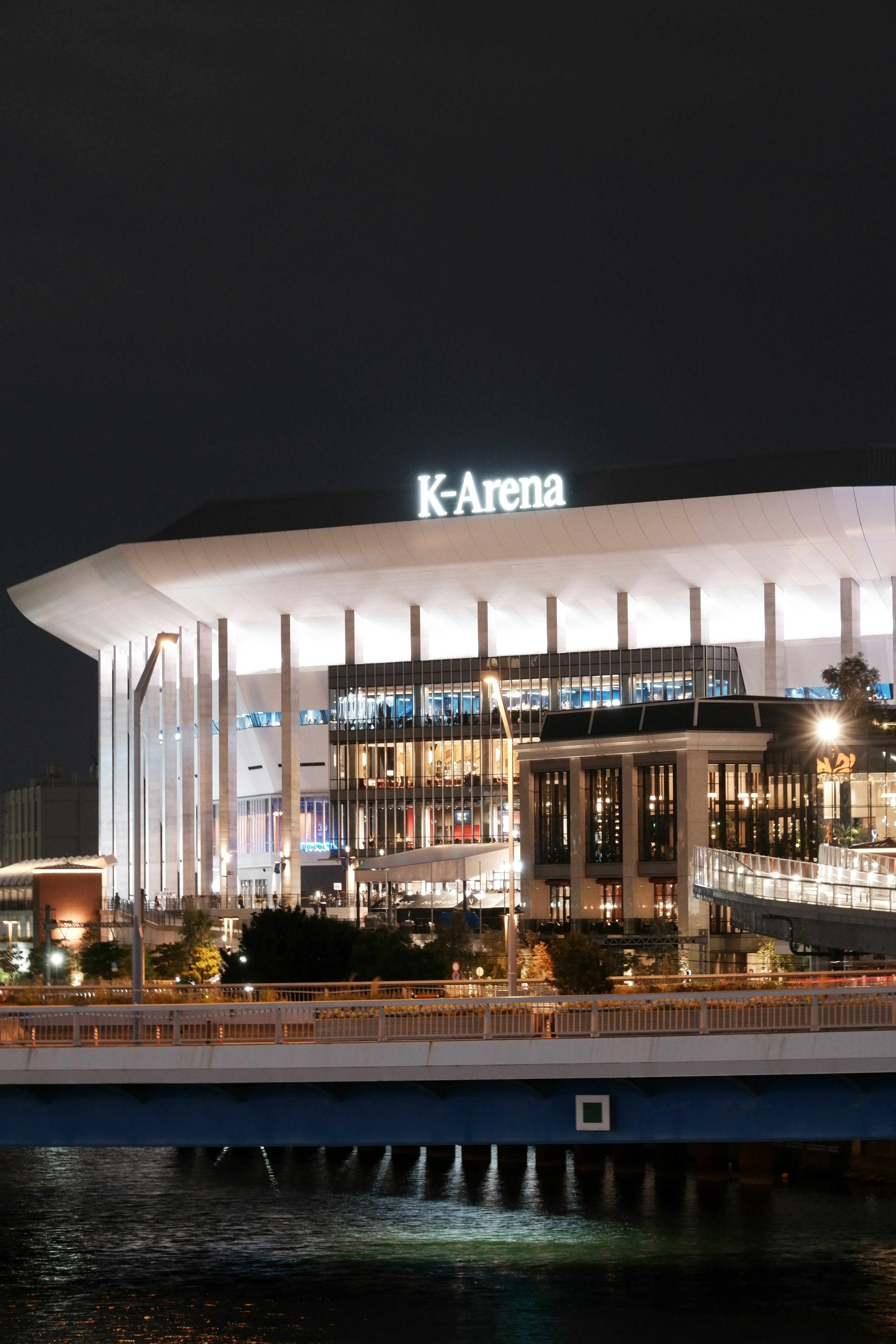 Pemandangan malam K-Arena dengan lampu terang dan arsitektur modern