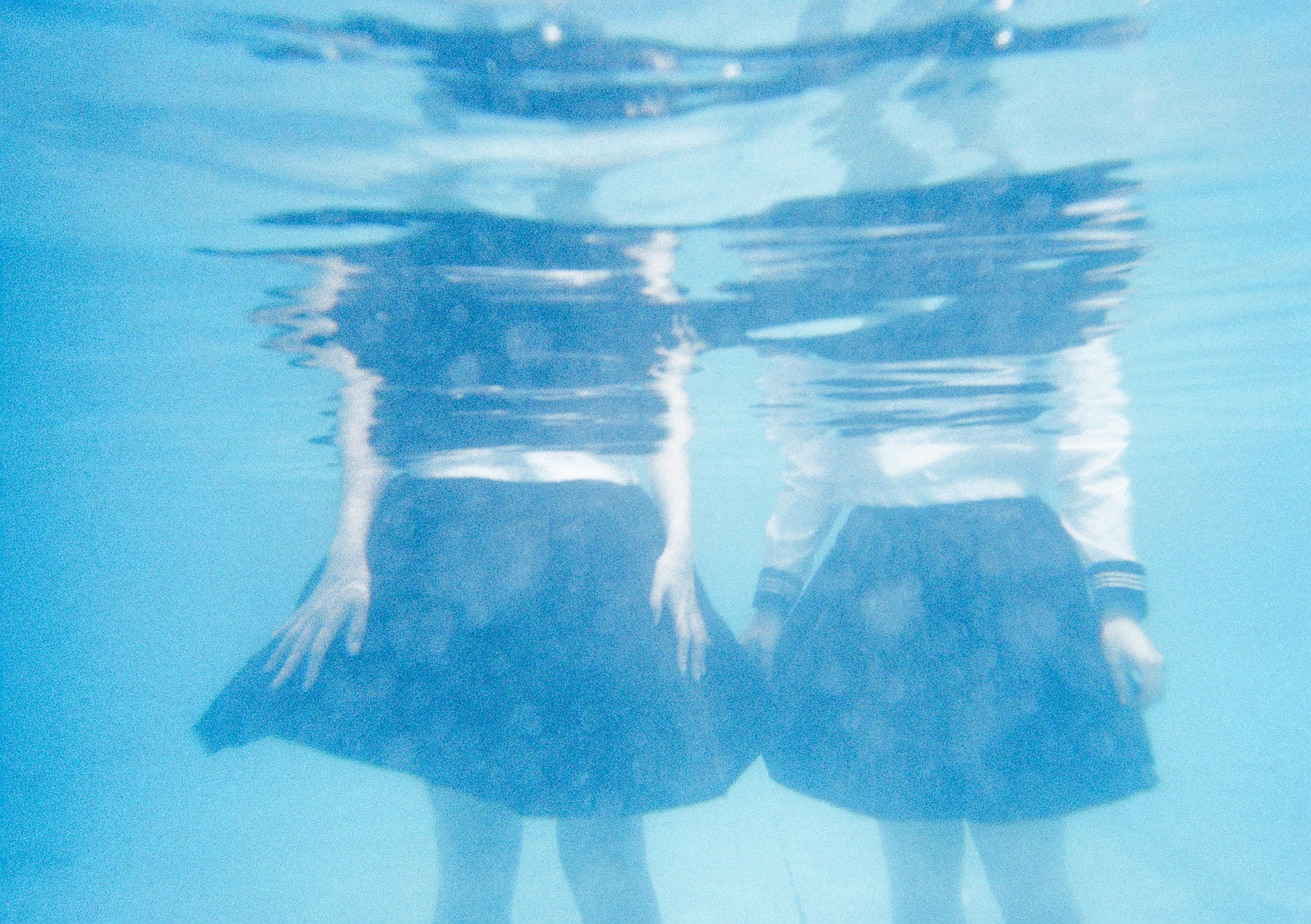 Deux filles visibles sous l'eau entourées d'eau bleue