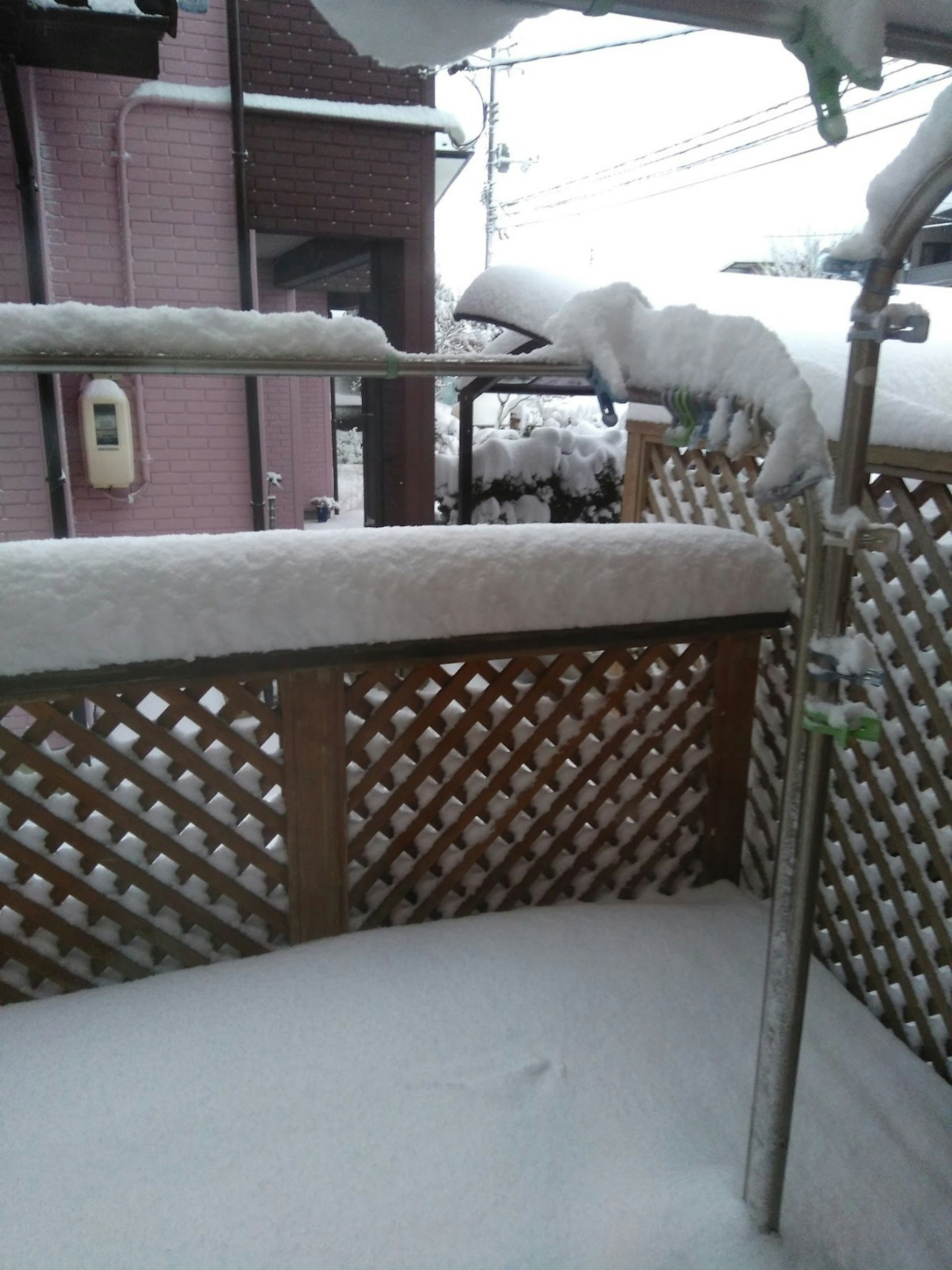 Snow-covered balcony scene with wooden fence and accumulated snow