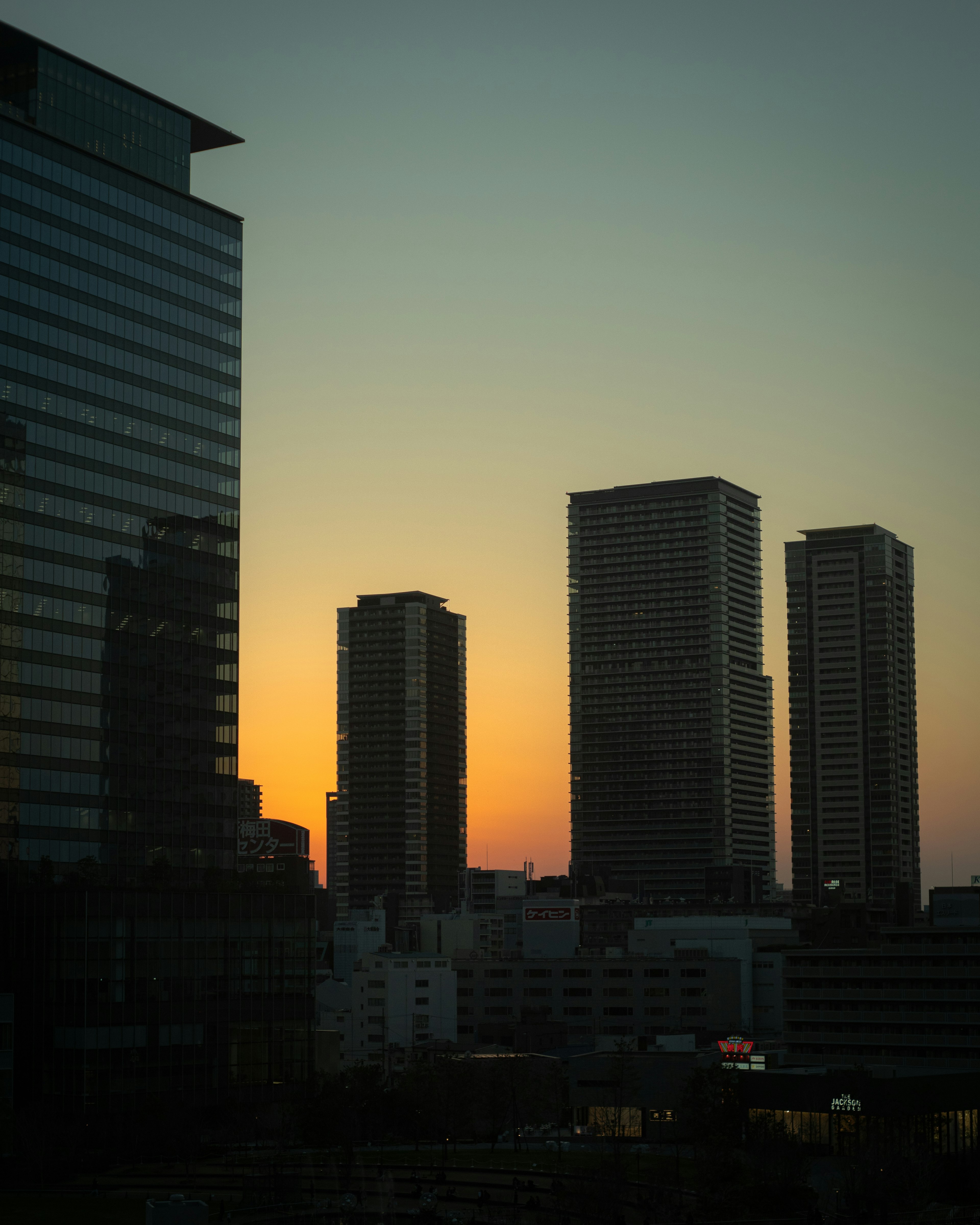 Silhouette of skyscrapers against a sunset sky