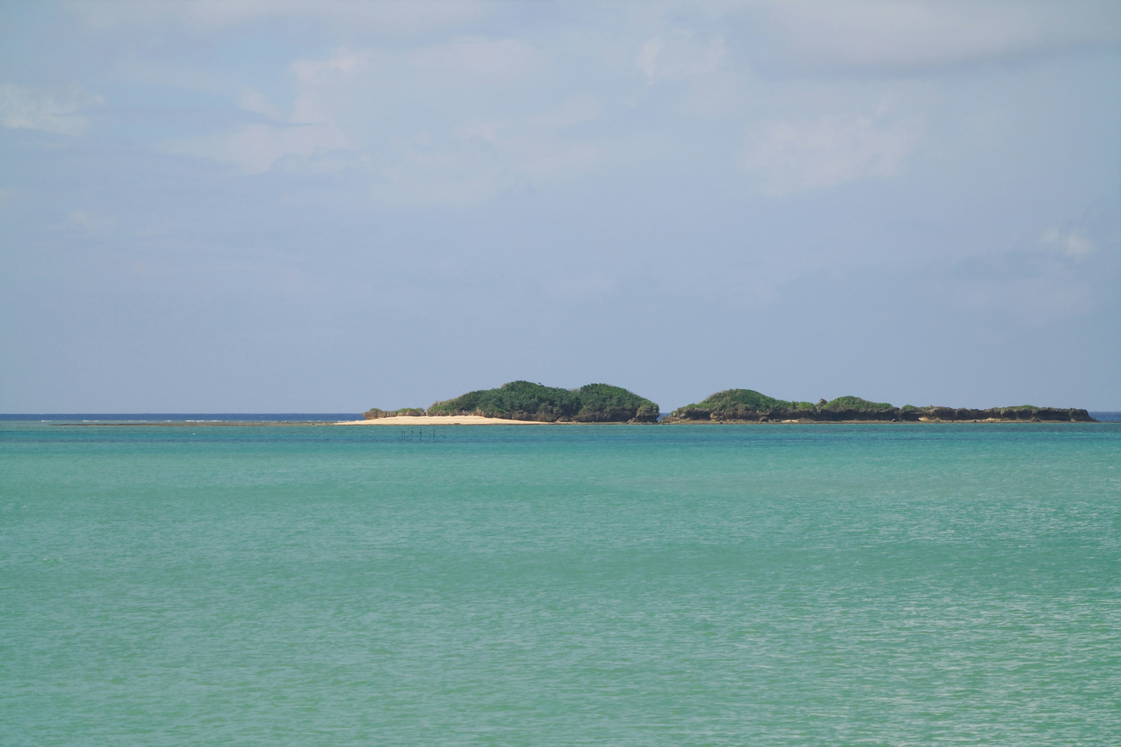 Scenic view of turquoise water with small islands in the distance